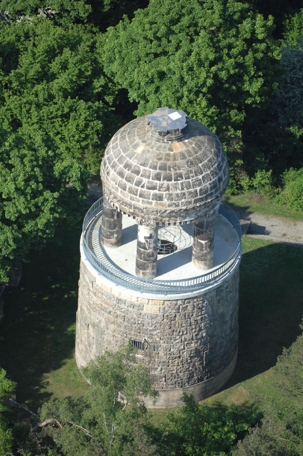 HALBERSTADT from the bird's eye view: Blick auf den Bismarckturm im Landschaftsschutzpark Spiegelsberge in Halberstadt. Seitlich von der Halle führen zwei Treppen mit 29 Kunststeinstufen zur ersten und 17 Eisenstufen einer Wendeltreppe zur Aussichtsplattform. Über der Aussichtsplattform erhebt sich auf fünf wuchtigen Säulen ein Kuppelbau mit rundem Feuerbecken. Nach dem 2. Weltkrieg wurde der Bismarckturm in Turm des Friedens umbenannt. Der Turm wurde nicht saniert. Im Jahr 1965 hatte man die Idee, den Turm in eine Volkssternwarte umzubauen. Dieser Gedanke wurde aber wieder verworfen. Nach der Wende wurde der Turm 1992 unter Denkmalschutz gestellt und in den Jahren 1996-98 saniert (Wiedereröffnung am 21.07.1998). Die Rückbenennung in Bismarckturm erfolgte ca. 1992.