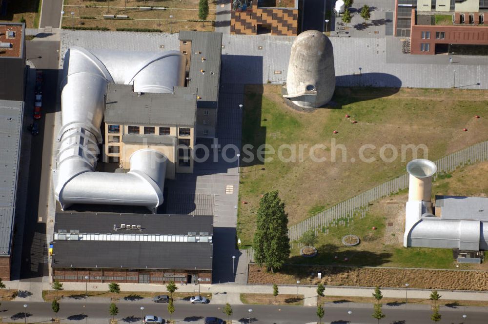 Berlin from above - Blick auf den Aerodynamischen Park in Berlin Adlershof. Er ist Teil einer Folge von Plätzen und Freiräumen. Seinen Namen erhielt dieser kleine Park (Landschaftsgestaltung durch das Büro Thomanek und Duquesnoy) durch drei eigentümliche Architekturen: Der Trudelturm, der Schallgedämpfte Motorenprüfstand und der Große Windkanal. Die Baudenkmale wurden im Laufe der 1920er und 1930er Jahre als Bestandteile der damals am Flugplatz Johannisthal angesiedelten Deutschen Versuchsanstalt für Luftfahrt errichtet.