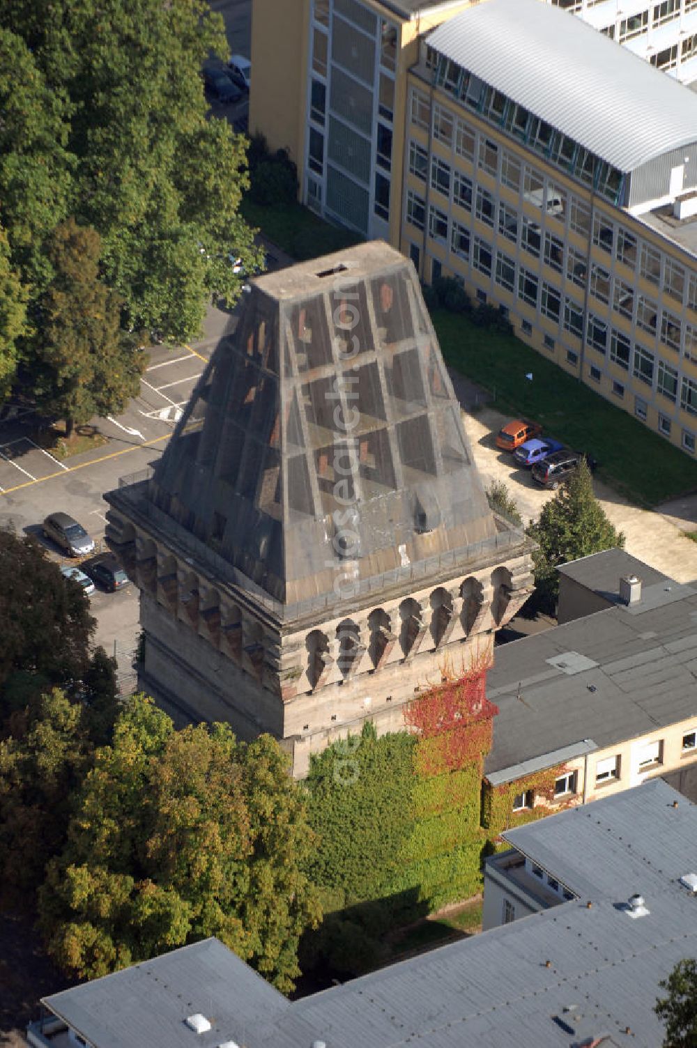 Aerial photograph Trier - Blick auf den Augustinerhof mit dem unvollendeten Hochbunker in Trier. Der Bunker befindet sich direkt neben dem Rathaus, ist 38 Meter hoch und steht unter Denkmalschutz. Im Jahr 1942 wurde er auf staatliche Veranlassung hin gebaut und sollte den Beamten der Stadt, sowie der Zivilbevölkerung Schutz vor Luftangriffen bieten. Die unvollendete Dachspitze sollte direkte Treffer einer Bombe verhindern und dafür sorgen, dass diese am Dach abprallen und so auf dem Boden neben dem Haus aufschlagen würde. Die Drahtbespannung des Dachstuhls wurde bisher zweimal erneuert (1980 und 2005) um das Herabfallen von Betonteilen zu verhindern. Derzeit wird darüber nachgedacht das Gebäude umzubauen und so die Nutzungsmöglichkeiten zu erweitern.