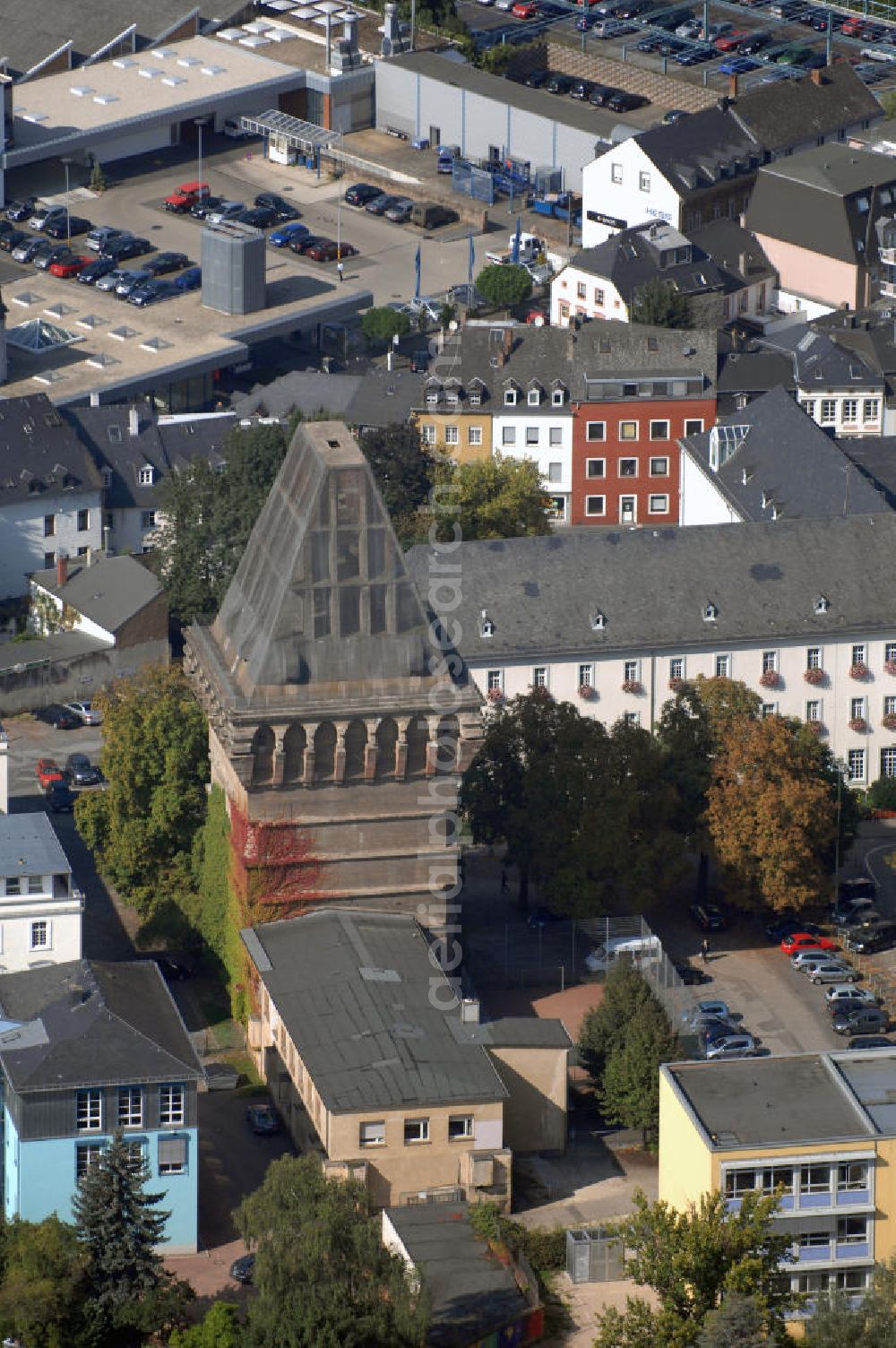 Trier from the bird's eye view: Blick auf den Augustinerhof mit dem unvollendeten Hochbunker in Trier. Der Bunker befindet sich direkt neben dem Rathaus, ist 38 Meter hoch und steht unter Denkmalschutz. Im Jahr 1942 wurde er auf staatliche Veranlassung hin gebaut und sollte den Beamten der Stadt, sowie der Zivilbevölkerung Schutz vor Luftangriffen bieten. Die unvollendete Dachspitze sollte direkte Treffer einer Bombe verhindern und dafür sorgen, dass diese am Dach abprallen und so auf dem Boden neben dem Haus aufschlagen würde. Die Drahtbespannung des Dachstuhls wurde bisher zweimal erneuert (1980 und 2005) um das Herabfallen von Betonteilen zu verhindern. Derzeit wird darüber nachgedacht das Gebäude umzubauen und so die Nutzungsmöglichkeiten zu erweitern.