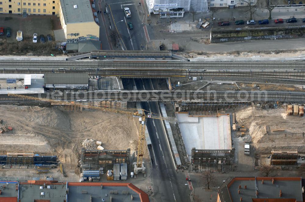 Berlin from the bird's eye view: Blick auf den Um- und Ausbau des S-Bahnhofes Berlin-Baumschulenweg.Die Fassade des Haupteinganges auf der Ostseite, die der Bahnhof 1916 erhielt und die heute unter Denkmalschutz steht, bleibt dabei erhalten. Ansonsten wird der erneuerungsbedürftige Bahnhof künftig modernen Ansprüchen an Komfort, Sicherheit, Gestaltung und Leistungsfähigkeit gerecht. Rund 28 Millionen Euro werden investiert.Die Brücken der drei S-Bahn- und zwei Fernbahngleise werden neu gebaut. Die Breite der Baumschulenstraße bleibt erhalten, ebenso die auf 3,80 Meter beschränkte Durchfahrtshöhe.Die S-Bahnsteige werden neu gebaut und beide liegen künftig fast mittig über der Baumschulenstraße. Auch nach dem Umbau wird es drei S-Bahngleise mit einem Seitenbahnsteig für die Züge Richtung Stadt und einem Inselbahnsteig für die Züge Richtung Schöneweide geben. Ausführende Baufirma ist die EUROVIA Infra GmbH.