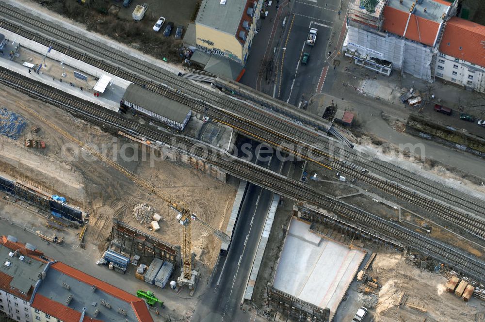 Aerial photograph Berlin - Blick auf den Um- und Ausbau des S-Bahnhofes Berlin-Baumschulenweg.Die Fassade des Haupteinganges auf der Ostseite, die der Bahnhof 1916 erhielt und die heute unter Denkmalschutz steht, bleibt dabei erhalten. Ansonsten wird der erneuerungsbedürftige Bahnhof künftig modernen Ansprüchen an Komfort, Sicherheit, Gestaltung und Leistungsfähigkeit gerecht. Rund 28 Millionen Euro werden investiert.Die Brücken der drei S-Bahn- und zwei Fernbahngleise werden neu gebaut. Die Breite der Baumschulenstraße bleibt erhalten, ebenso die auf 3,80 Meter beschränkte Durchfahrtshöhe.Die S-Bahnsteige werden neu gebaut und beide liegen künftig fast mittig über der Baumschulenstraße. Auch nach dem Umbau wird es drei S-Bahngleise mit einem Seitenbahnsteig für die Züge Richtung Stadt und einem Inselbahnsteig für die Züge Richtung Schöneweide geben. Ausführende Baufirma ist die EUROVIA Infra GmbH.