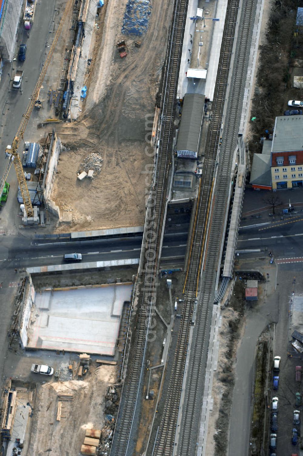 Berlin from the bird's eye view: Blick auf den Um- und Ausbau des S-Bahnhofes Berlin-Baumschulenweg.Die Fassade des Haupteinganges auf der Ostseite, die der Bahnhof 1916 erhielt und die heute unter Denkmalschutz steht, bleibt dabei erhalten. Ansonsten wird der erneuerungsbedürftige Bahnhof künftig modernen Ansprüchen an Komfort, Sicherheit, Gestaltung und Leistungsfähigkeit gerecht. Rund 28 Millionen Euro werden investiert.Die Brücken der drei S-Bahn- und zwei Fernbahngleise werden neu gebaut. Die Breite der Baumschulenstraße bleibt erhalten, ebenso die auf 3,80 Meter beschränkte Durchfahrtshöhe.Die S-Bahnsteige werden neu gebaut und beide liegen künftig fast mittig über der Baumschulenstraße. Auch nach dem Umbau wird es drei S-Bahngleise mit einem Seitenbahnsteig für die Züge Richtung Stadt und einem Inselbahnsteig für die Züge Richtung Schöneweide geben. Ausführende Baufirma ist die EUROVIA Infra GmbH.