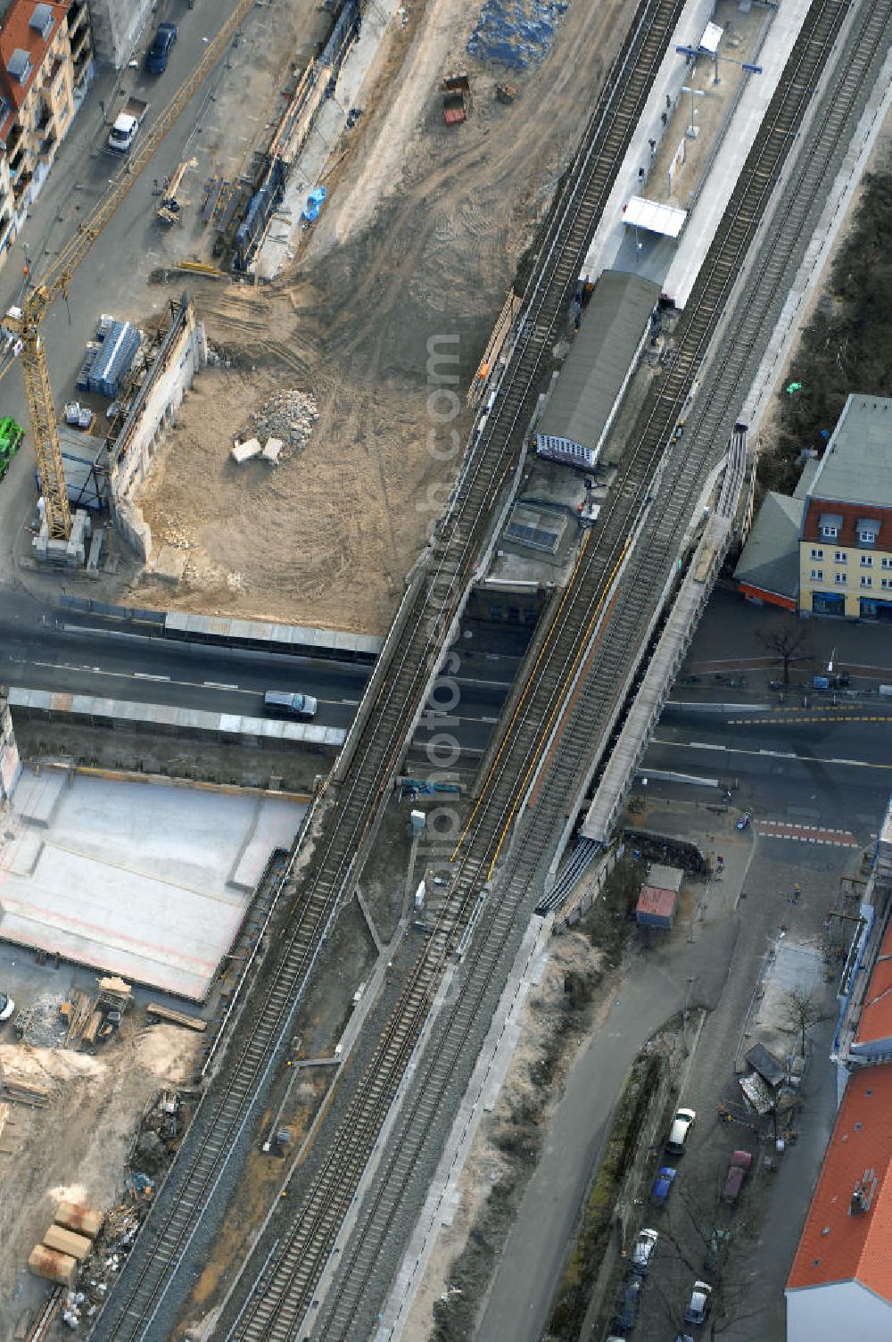 Aerial image Berlin - Blick auf den Um- und Ausbau des S-Bahnhofes Berlin-Baumschulenweg.Die Fassade des Haupteinganges auf der Ostseite, die der Bahnhof 1916 erhielt und die heute unter Denkmalschutz steht, bleibt dabei erhalten. Ansonsten wird der erneuerungsbedürftige Bahnhof künftig modernen Ansprüchen an Komfort, Sicherheit, Gestaltung und Leistungsfähigkeit gerecht. Rund 28 Millionen Euro werden investiert.Die Brücken der drei S-Bahn- und zwei Fernbahngleise werden neu gebaut. Die Breite der Baumschulenstraße bleibt erhalten, ebenso die auf 3,80 Meter beschränkte Durchfahrtshöhe.Die S-Bahnsteige werden neu gebaut und beide liegen künftig fast mittig über der Baumschulenstraße. Auch nach dem Umbau wird es drei S-Bahngleise mit einem Seitenbahnsteig für die Züge Richtung Stadt und einem Inselbahnsteig für die Züge Richtung Schöneweide geben. Ausführende Baufirma ist die EUROVIA Infra GmbH.