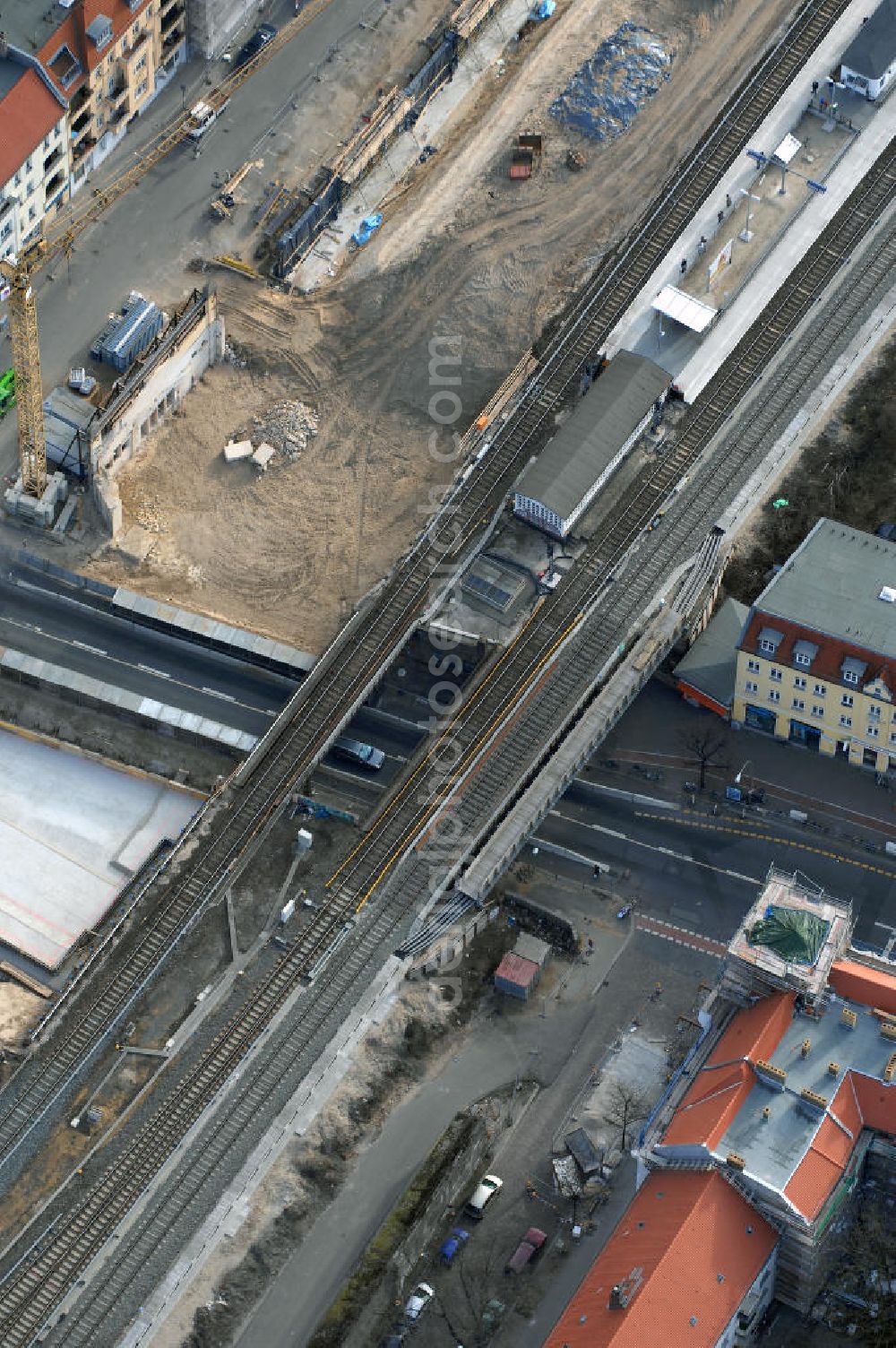 Aerial photograph Berlin - Blick auf den Um- und Ausbau des S-Bahnhofes Berlin-Baumschulenweg.Die Fassade des Haupteinganges auf der Ostseite, die der Bahnhof 1916 erhielt und die heute unter Denkmalschutz steht, bleibt dabei erhalten. Ansonsten wird der erneuerungsbedürftige Bahnhof künftig modernen Ansprüchen an Komfort, Sicherheit, Gestaltung und Leistungsfähigkeit gerecht. Rund 28 Millionen Euro werden investiert.Die Brücken der drei S-Bahn- und zwei Fernbahngleise werden neu gebaut. Die Breite der Baumschulenstraße bleibt erhalten, ebenso die auf 3,80 Meter beschränkte Durchfahrtshöhe.Die S-Bahnsteige werden neu gebaut und beide liegen künftig fast mittig über der Baumschulenstraße. Auch nach dem Umbau wird es drei S-Bahngleise mit einem Seitenbahnsteig für die Züge Richtung Stadt und einem Inselbahnsteig für die Züge Richtung Schöneweide geben. Ausführende Baufirma ist die EUROVIA Infra GmbH.