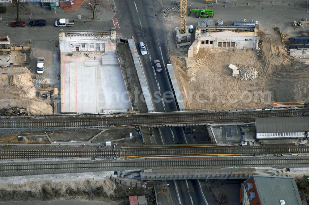 Aerial image Berlin - Blick auf den Um- und Ausbau des S-Bahnhofes Berlin-Baumschulenweg.Die Fassade des Haupteinganges auf der Ostseite, die der Bahnhof 1916 erhielt und die heute unter Denkmalschutz steht, bleibt dabei erhalten. Ansonsten wird der erneuerungsbedürftige Bahnhof künftig modernen Ansprüchen an Komfort, Sicherheit, Gestaltung und Leistungsfähigkeit gerecht. Rund 28 Millionen Euro werden investiert.Die Brücken der drei S-Bahn- und zwei Fernbahngleise werden neu gebaut. Die Breite der Baumschulenstraße bleibt erhalten, ebenso die auf 3,80 Meter beschränkte Durchfahrtshöhe.Die S-Bahnsteige werden neu gebaut und beide liegen künftig fast mittig über der Baumschulenstraße. Auch nach dem Umbau wird es drei S-Bahngleise mit einem Seitenbahnsteig für die Züge Richtung Stadt und einem Inselbahnsteig für die Züge Richtung Schöneweide geben. Ausführende Baufirma ist die EUROVIA Infra GmbH.