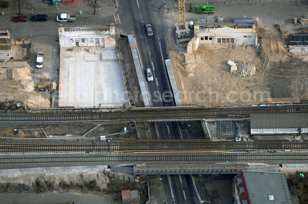 Aerial photograph Berlin - Blick auf den Um- und Ausbau des S-Bahnhofes Berlin-Baumschulenweg.Die Fassade des Haupteinganges auf der Ostseite, die der Bahnhof 1916 erhielt und die heute unter Denkmalschutz steht, bleibt dabei erhalten. Ansonsten wird der erneuerungsbedürftige Bahnhof künftig modernen Ansprüchen an Komfort, Sicherheit, Gestaltung und Leistungsfähigkeit gerecht. Rund 28 Millionen Euro werden investiert.Die Brücken der drei S-Bahn- und zwei Fernbahngleise werden neu gebaut. Die Breite der Baumschulenstraße bleibt erhalten, ebenso die auf 3,80 Meter beschränkte Durchfahrtshöhe.Die S-Bahnsteige werden neu gebaut und beide liegen künftig fast mittig über der Baumschulenstraße. Auch nach dem Umbau wird es drei S-Bahngleise mit einem Seitenbahnsteig für die Züge Richtung Stadt und einem Inselbahnsteig für die Züge Richtung Schöneweide geben. Ausführende Baufirma ist die EUROVIA Infra GmbH.