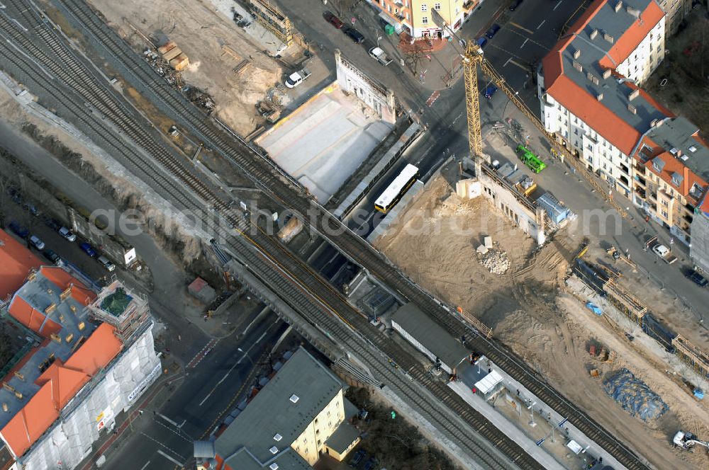 Aerial photograph Berlin - Blick auf den Um- und Ausbau des S-Bahnhofes Berlin-Baumschulenweg.Die Fassade des Haupteinganges auf der Ostseite, die der Bahnhof 1916 erhielt und die heute unter Denkmalschutz steht, bleibt dabei erhalten. Ansonsten wird der erneuerungsbedürftige Bahnhof künftig modernen Ansprüchen an Komfort, Sicherheit, Gestaltung und Leistungsfähigkeit gerecht. Rund 28 Millionen Euro werden investiert.Die Brücken der drei S-Bahn- und zwei Fernbahngleise werden neu gebaut. Die Breite der Baumschulenstraße bleibt erhalten, ebenso die auf 3,80 Meter beschränkte Durchfahrtshöhe.Die S-Bahnsteige werden neu gebaut und beide liegen künftig fast mittig über der Baumschulenstraße. Auch nach dem Umbau wird es drei S-Bahngleise mit einem Seitenbahnsteig für die Züge Richtung Stadt und einem Inselbahnsteig für die Züge Richtung Schöneweide geben. Ausführende Baufirma ist die EUROVIA Infra GmbH.