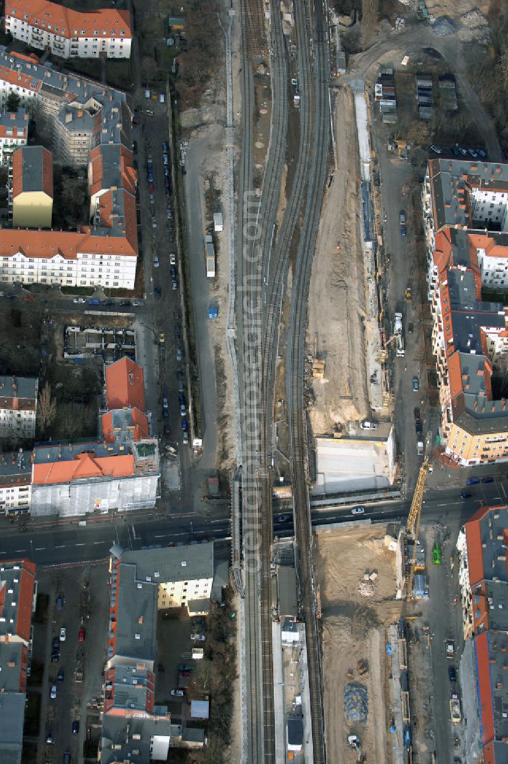 Aerial photograph Berlin - Blick auf den Um- und Ausbau des S-Bahnhofes Berlin-Baumschulenweg.Die Fassade des Haupteinganges auf der Ostseite, die der Bahnhof 1916 erhielt und die heute unter Denkmalschutz steht, bleibt dabei erhalten. Ansonsten wird der erneuerungsbedürftige Bahnhof künftig modernen Ansprüchen an Komfort, Sicherheit, Gestaltung und Leistungsfähigkeit gerecht. Rund 28 Millionen Euro werden investiert.Die Brücken der drei S-Bahn- und zwei Fernbahngleise werden neu gebaut. Die Breite der Baumschulenstraße bleibt erhalten, ebenso die auf 3,80 Meter beschränkte Durchfahrtshöhe.Die S-Bahnsteige werden neu gebaut und beide liegen künftig fast mittig über der Baumschulenstraße. Auch nach dem Umbau wird es drei S-Bahngleise mit einem Seitenbahnsteig für die Züge Richtung Stadt und einem Inselbahnsteig für die Züge Richtung Schöneweide geben. Ausführende Baufirma ist die EUROVIA Infra GmbH.