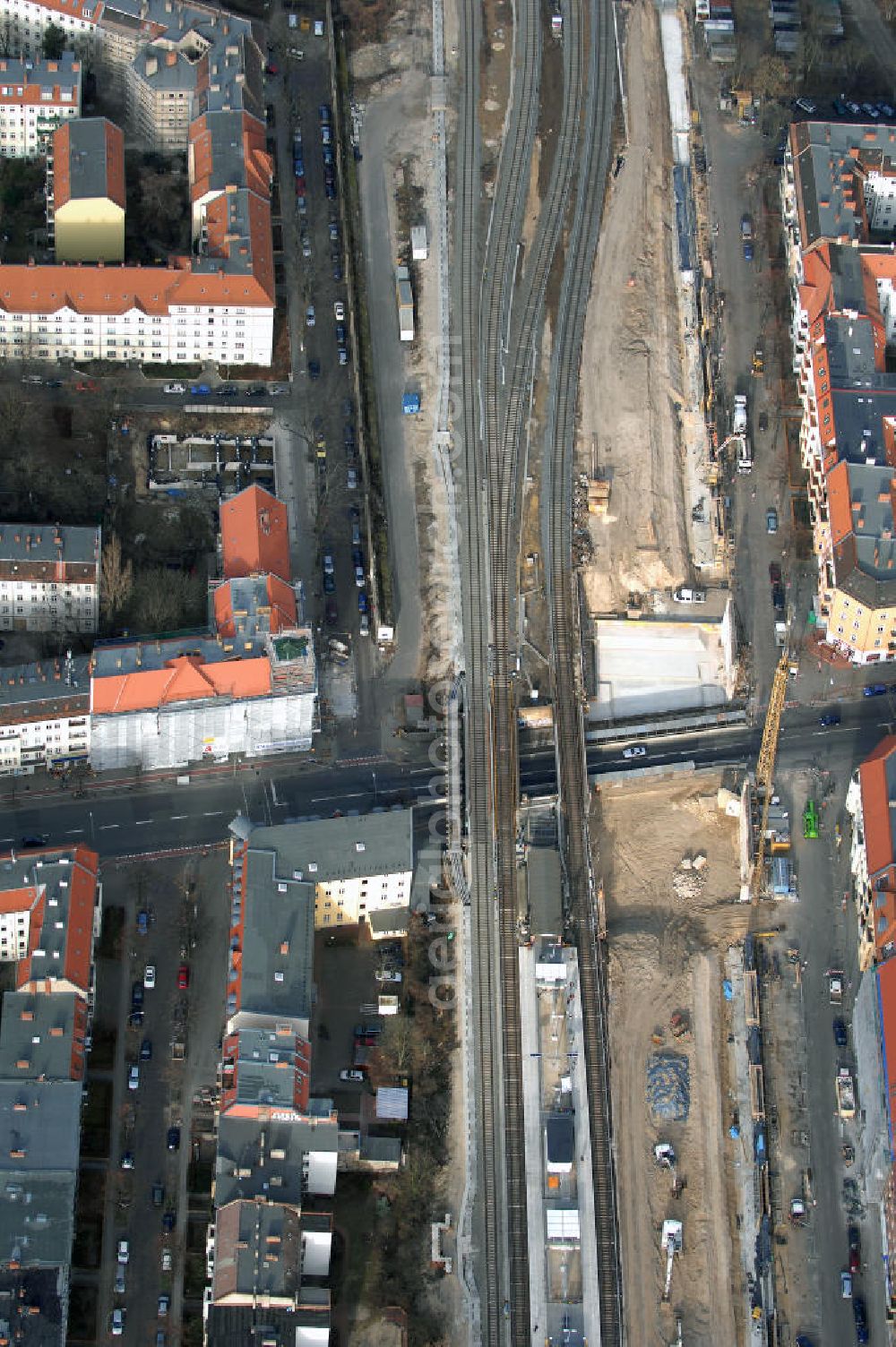 Berlin from above - Blick auf den Um- und Ausbau des S-Bahnhofes Berlin-Baumschulenweg.Die Fassade des Haupteinganges auf der Ostseite, die der Bahnhof 1916 erhielt und die heute unter Denkmalschutz steht, bleibt dabei erhalten. Ansonsten wird der erneuerungsbedürftige Bahnhof künftig modernen Ansprüchen an Komfort, Sicherheit, Gestaltung und Leistungsfähigkeit gerecht. Rund 28 Millionen Euro werden investiert.Die Brücken der drei S-Bahn- und zwei Fernbahngleise werden neu gebaut. Die Breite der Baumschulenstraße bleibt erhalten, ebenso die auf 3,80 Meter beschränkte Durchfahrtshöhe.Die S-Bahnsteige werden neu gebaut und beide liegen künftig fast mittig über der Baumschulenstraße. Auch nach dem Umbau wird es drei S-Bahngleise mit einem Seitenbahnsteig für die Züge Richtung Stadt und einem Inselbahnsteig für die Züge Richtung Schöneweide geben. Ausführende Baufirma ist die EUROVIA Infra GmbH.