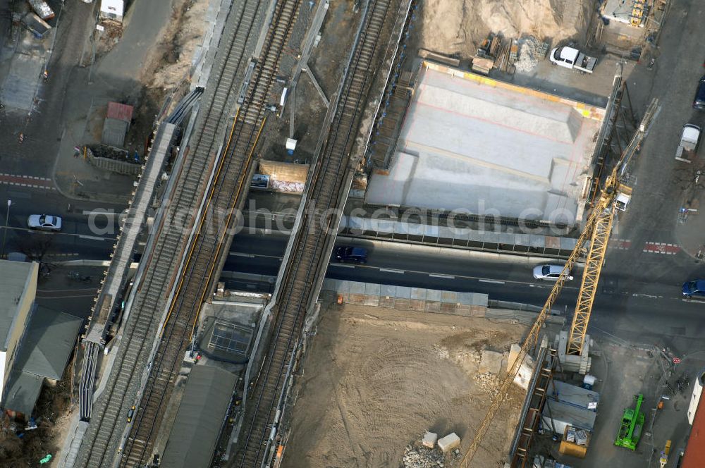 Berlin from the bird's eye view: Blick auf den Um- und Ausbau des S-Bahnhofes Berlin-Baumschulenweg.Die Fassade des Haupteinganges auf der Ostseite, die der Bahnhof 1916 erhielt und die heute unter Denkmalschutz steht, bleibt dabei erhalten. Ansonsten wird der erneuerungsbedürftige Bahnhof künftig modernen Ansprüchen an Komfort, Sicherheit, Gestaltung und Leistungsfähigkeit gerecht. Rund 28 Millionen Euro werden investiert.Die Brücken der drei S-Bahn- und zwei Fernbahngleise werden neu gebaut. Die Breite der Baumschulenstraße bleibt erhalten, ebenso die auf 3,80 Meter beschränkte Durchfahrtshöhe.Die S-Bahnsteige werden neu gebaut und beide liegen künftig fast mittig über der Baumschulenstraße. Auch nach dem Umbau wird es drei S-Bahngleise mit einem Seitenbahnsteig für die Züge Richtung Stadt und einem Inselbahnsteig für die Züge Richtung Schöneweide geben. Ausführende Baufirma ist die EUROVIA Infra GmbH.