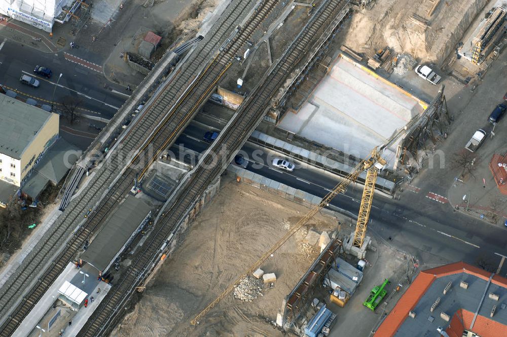 Aerial image Berlin - Blick auf den Um- und Ausbau des S-Bahnhofes Berlin-Baumschulenweg.Die Fassade des Haupteinganges auf der Ostseite, die der Bahnhof 1916 erhielt und die heute unter Denkmalschutz steht, bleibt dabei erhalten. Ansonsten wird der erneuerungsbedürftige Bahnhof künftig modernen Ansprüchen an Komfort, Sicherheit, Gestaltung und Leistungsfähigkeit gerecht. Rund 28 Millionen Euro werden investiert.Die Brücken der drei S-Bahn- und zwei Fernbahngleise werden neu gebaut. Die Breite der Baumschulenstraße bleibt erhalten, ebenso die auf 3,80 Meter beschränkte Durchfahrtshöhe.Die S-Bahnsteige werden neu gebaut und beide liegen künftig fast mittig über der Baumschulenstraße. Auch nach dem Umbau wird es drei S-Bahngleise mit einem Seitenbahnsteig für die Züge Richtung Stadt und einem Inselbahnsteig für die Züge Richtung Schöneweide geben. Ausführende Baufirma ist die EUROVIA Infra GmbH.