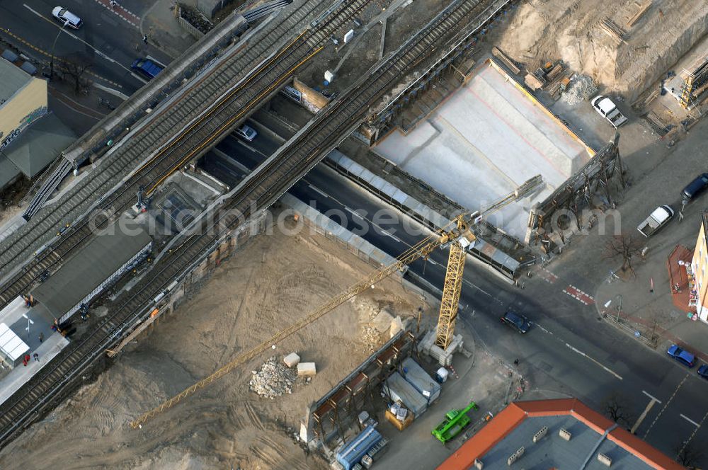 Aerial photograph Berlin - Blick auf den Um- und Ausbau des S-Bahnhofes Berlin-Baumschulenweg.Die Fassade des Haupteinganges auf der Ostseite, die der Bahnhof 1916 erhielt und die heute unter Denkmalschutz steht, bleibt dabei erhalten. Ansonsten wird der erneuerungsbedürftige Bahnhof künftig modernen Ansprüchen an Komfort, Sicherheit, Gestaltung und Leistungsfähigkeit gerecht. Rund 28 Millionen Euro werden investiert.Die Brücken der drei S-Bahn- und zwei Fernbahngleise werden neu gebaut. Die Breite der Baumschulenstraße bleibt erhalten, ebenso die auf 3,80 Meter beschränkte Durchfahrtshöhe.Die S-Bahnsteige werden neu gebaut und beide liegen künftig fast mittig über der Baumschulenstraße. Auch nach dem Umbau wird es drei S-Bahngleise mit einem Seitenbahnsteig für die Züge Richtung Stadt und einem Inselbahnsteig für die Züge Richtung Schöneweide geben. Ausführende Baufirma ist die EUROVIA Infra GmbH.