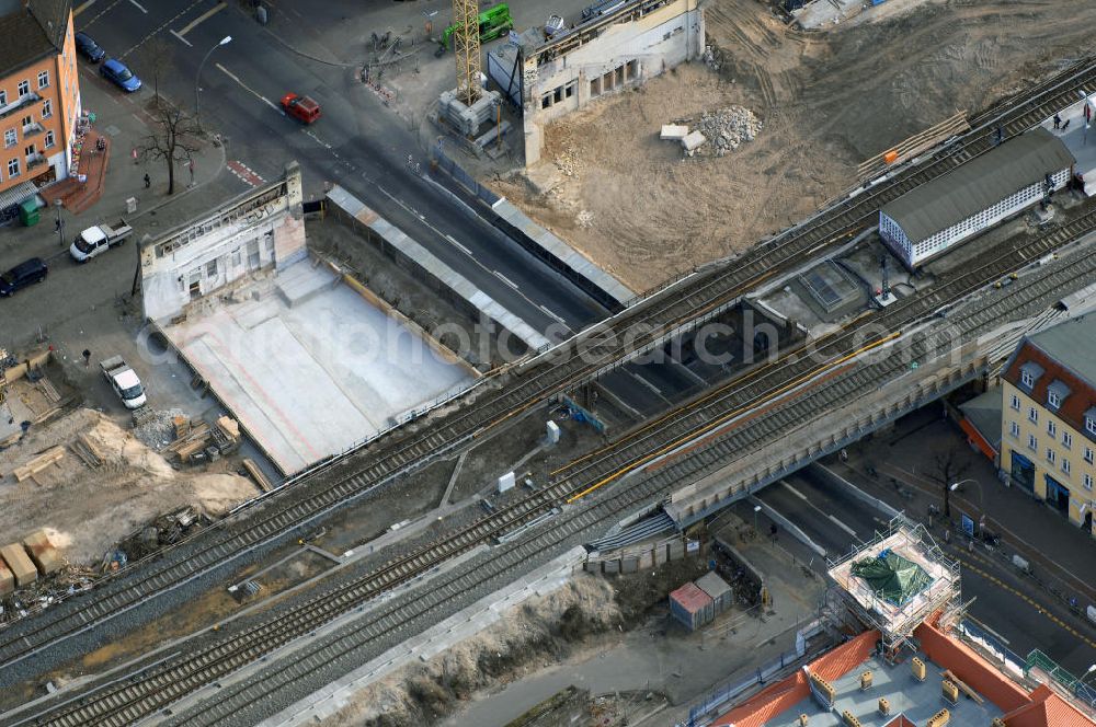 Aerial image Berlin - Blick auf den Um- und Ausbau des S-Bahnhofes Berlin-Baumschulenweg.Die Fassade des Haupteinganges auf der Ostseite, die der Bahnhof 1916 erhielt und die heute unter Denkmalschutz steht, bleibt dabei erhalten. Ansonsten wird der erneuerungsbedürftige Bahnhof künftig modernen Ansprüchen an Komfort, Sicherheit, Gestaltung und Leistungsfähigkeit gerecht. Rund 28 Millionen Euro werden investiert.Die Brücken der drei S-Bahn- und zwei Fernbahngleise werden neu gebaut. Die Breite der Baumschulenstraße bleibt erhalten, ebenso die auf 3,80 Meter beschränkte Durchfahrtshöhe.Die S-Bahnsteige werden neu gebaut und beide liegen künftig fast mittig über der Baumschulenstraße. Auch nach dem Umbau wird es drei S-Bahngleise mit einem Seitenbahnsteig für die Züge Richtung Stadt und einem Inselbahnsteig für die Züge Richtung Schöneweide geben. Ausführende Baufirma ist die EUROVIA Infra GmbH.