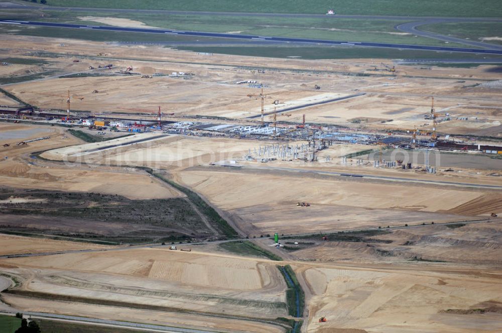 Berllin from the bird's eye view: Blick auf den Ausbau des Flughafen Schönefeld zum neuen Flughafen Berlin-Brandenburg. Betreiber wird die Flughafen Berlin-Schönefeld GmbH (FBS) sein. Der erste Spatenstich erfolgte am 5. September 2006. BBI ist eines der größten im Bau befindlichen Verkehrsinfrastrukturprojekte Deutschlands. Kern des Neubaufeldes ist der Bahnhof, er bildet das Fundament für das noch zu errichtende Fluggast-Terminal. Über zwei Bahnsteige für Regional- und Fernverkehr sowie einen S-Bahnsteig können die Reisenden in Zukunft dann direkt den Flughafen erreichen. Wenn der neue Flughafen Berlin Brandenburg International (BBI) 2011 eröffnet wird, sollen es rund 22 Millionen Passagiere in Berlin werden. Ausbau der A113n als südöstliches Tor zur Hauptstadt. Unter Berücksichtigung des Flughafens Berlin Brandenburg International wurde eine Verkehrskonzeption für den Ausbau des Straßennetzes im Raum Berlin-Schönefeld erarbeitet, die zwei Stufen umfasste. Die erste Stufe sah den vierstreifigen Ausbau der Bundesstraßen B 96a und B 179 mit der Anbindung des Flughafens über zwei Knotenpunkte vor. Inhalt der zweiten Stufe war der Anschluß der Bundesautobahn A 113 neu an die B 96a und B 179. SCHÜßLER Plan Ingenieurgesellschaft, BATEG, EUROVIA, BERGER. Berliner Flughäfen: Ralf Kunkel, Tel. +49 (0)30 6091 2055, Fax +49 (0)30 6091 1643