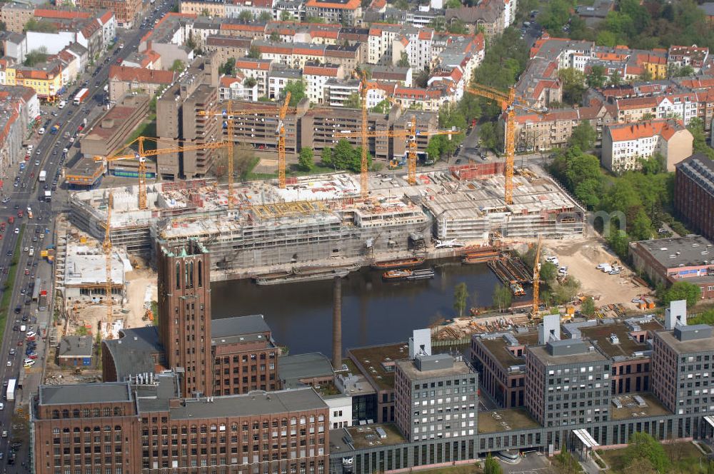 Aerial image Berlin - Blick auf die Baustelle vom Umbau Hafen Tempelhof am Ullsteinhaus. Der Tempelhofer Hafen entstand 1906 zusammen mit dem Teltowkanal. Zwei Jahre später kam der Speicher hinzu, eine der ersten Stahlbetonbauten in Deutschland. Im Krieg wurde das Gebäude schwer zerstört. Nach dem Wiederaufbau lagerte dort ein Teil der Lebensmittel-Reserve für West-Berlin. Bis zum Herbst 2008 sollen neben einer Einzelhandelsfläche von knapp 20 000 Quadratmetern und eine Fläche von etwa 10000 Quadratmeter für Unterhaltung, Grünflächen und Flanierwege entstehen. Hierfür wird der alte Speicher von einem Neubau flankiert. Etwa 70 Geschäfte haben in beiden Gebäuden Platz. Auf dem Dach des Neubaus entstehen 600 Parkplätze. Der Hafen selbst bleibt exklusiv Fußgängern und Freizeitkapitänen vorbehalten. Adresse: Ordensmeisterstraße, 12099 Berlin-Tempelhof; Kontakt Architekt: REM+tec Architekten, Gesellschaft für Projektentwicklung und Denkmalschutz mbH, Kurfürstenstraße 132, 10785 Berlin,Tel. 030 264767-70, Fax 030 264767-47, info@remtec.eu,