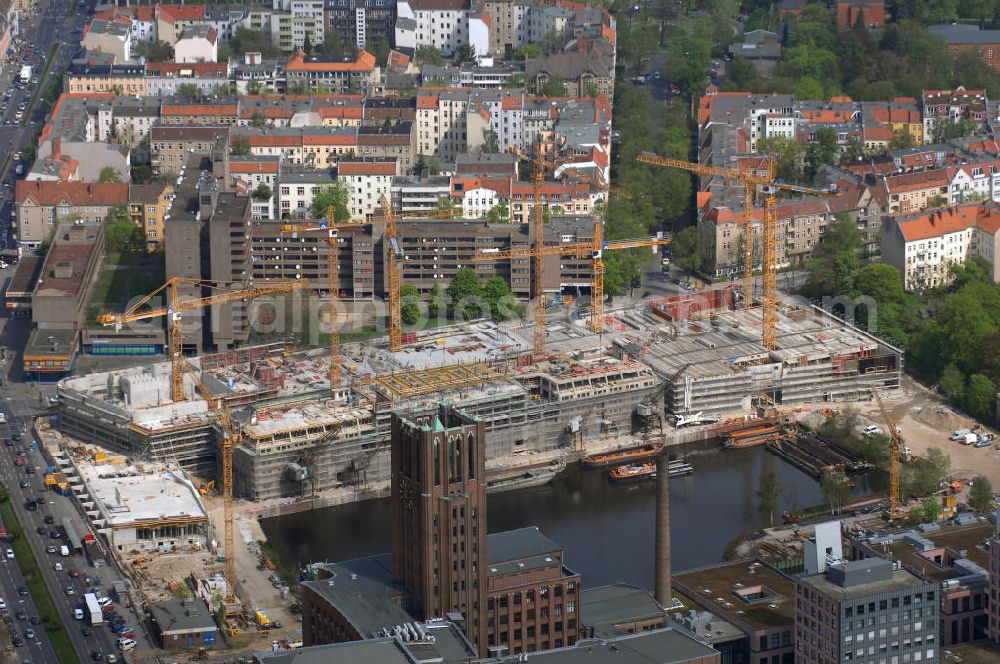 Aerial photograph Berlin - Blick auf die Baustelle vom Umbau Hafen Tempelhof am Ullsteinhaus. Der Tempelhofer Hafen entstand 1906 zusammen mit dem Teltowkanal. Zwei Jahre später kam der Speicher hinzu, eine der ersten Stahlbetonbauten in Deutschland. Im Krieg wurde das Gebäude schwer zerstört. Nach dem Wiederaufbau lagerte dort ein Teil der Lebensmittel-Reserve für West-Berlin. Bis zum Herbst 2008 sollen neben einer Einzelhandelsfläche von knapp 20 000 Quadratmetern und eine Fläche von etwa 10000 Quadratmeter für Unterhaltung, Grünflächen und Flanierwege entstehen. Hierfür wird der alte Speicher von einem Neubau flankiert. Etwa 70 Geschäfte haben in beiden Gebäuden Platz. Auf dem Dach des Neubaus entstehen 600 Parkplätze. Der Hafen selbst bleibt exklusiv Fußgängern und Freizeitkapitänen vorbehalten. Adresse: Ordensmeisterstraße, 12099 Berlin-Tempelhof; Kontakt Architekt: REM+tec Architekten, Gesellschaft für Projektentwicklung und Denkmalschutz mbH, Kurfürstenstraße 132, 10785 Berlin,Tel. 030 264767-70, Fax 030 264767-47, info@remtec.eu,