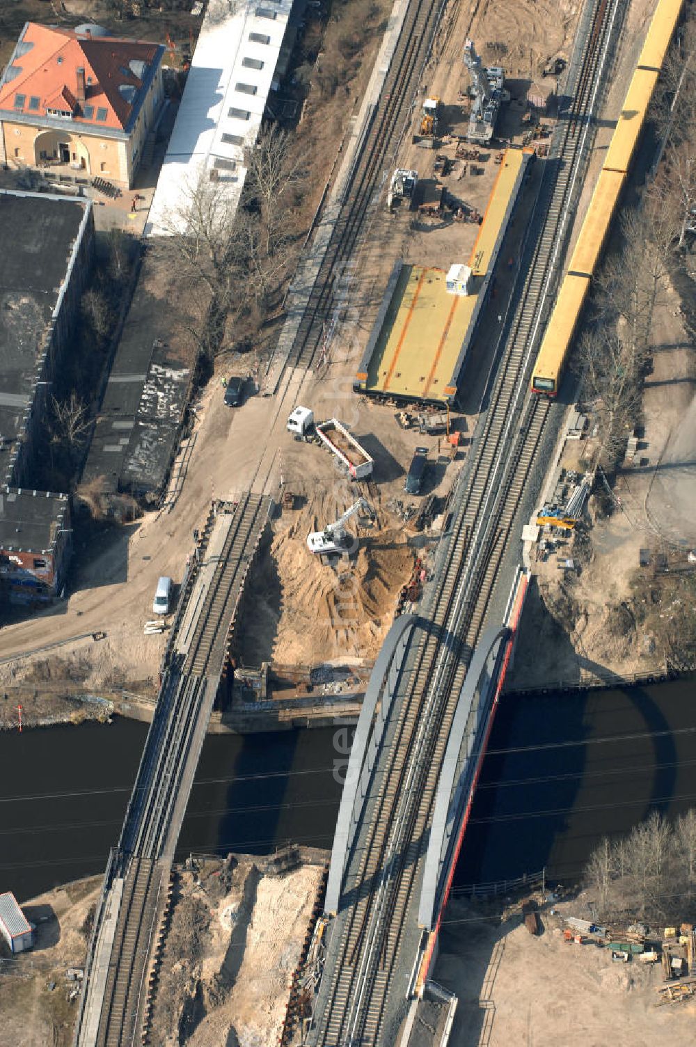 Aerial photograph Berlin - Blick auf die Baustelle vom Neubau der Bahnbrücken und Gleisverbindungen über den Britzer Zweigkanal am S-Bahnhof Berlin-Baumschulenweg. Ein Projekt der EUROVIA Infra GmbH. View onto the bridge constraction area over the canal Britzer Zweigkanal near the city railway station in Treptow-Köpenick.