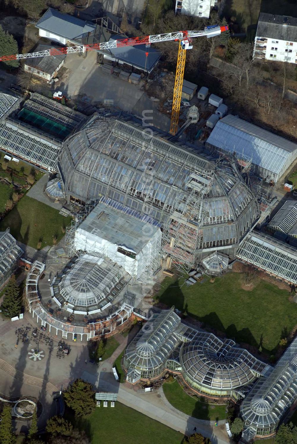 Berlin - Dahlem from the bird's eye view: Blick auf die Baustelle zur Grundsanierung des 100 Jahre alten Wahrzeichens des Botanischen Garten Berlin-Dahlem,dem Großen Tropenhauses.Die Grundsanierung des Großen Tropenhauses war unumgänglich, da das denkmalgeschützte Wahrzeichen für Wissenschaft, Forschung und Lehre sowie für die breite Öffentlichkeit dauerhaft erhalten werden soll. Alle technischen Anlagen sind stark überaltert und entsprechend störanfällig. Das Ausfallrisiko und somit das Gefährdungspotential für die wertvolle Pflanzensammlung ist hoch. Funktionierende Regelungsmöglichkeiten im heutigen Sinne existierten nicht. Die kranartige Befahranlage zur Pflege der riesigen Pflanzen und zur Wartung der Glashülle von innen kann nicht mehr eingesetzt werden. Millionen feiner Haarrisse durchziehen die großflächigen Verglasungen. Seit August 2006 dauernd die bis zum Dezember 2008 geplanten Sanierungsarbeiten.Botanischer Garten und Botanisches Museum Berlin-Dahlem (BGBM) Zentraleinrichtung der Freien Universität Berlin,Königin-Luise-Str. 6-8, 14195 Berlin,Telefon: (+4930) 838-50100 http://