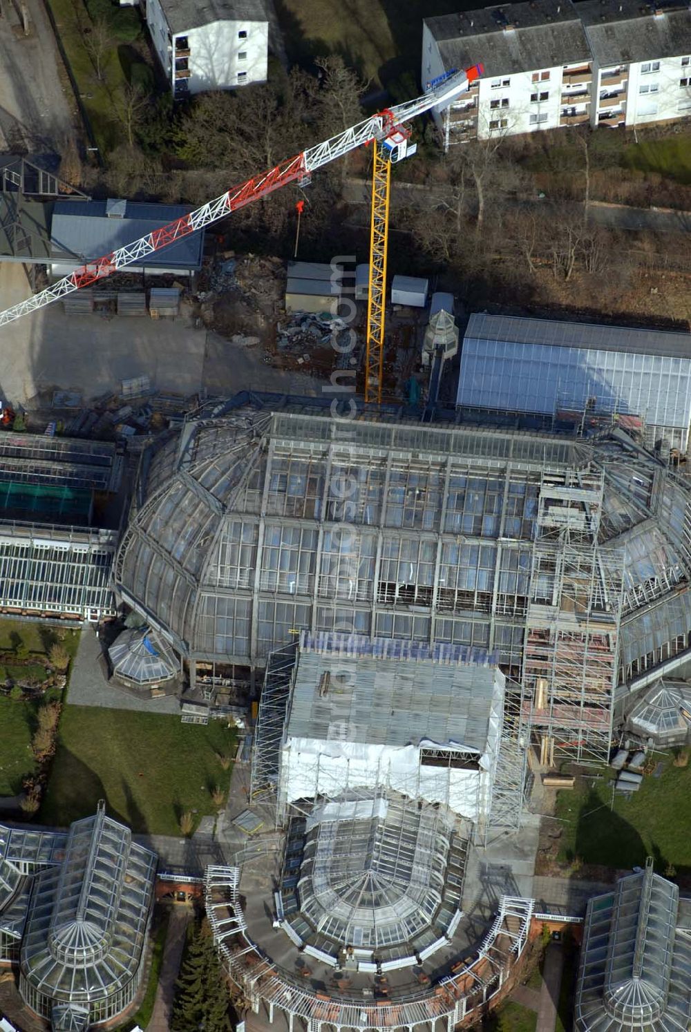 Aerial image Berlin - Dahlem - Blick auf die Baustelle zur Grundsanierung des 100 Jahre alten Wahrzeichens des Botanischen Garten Berlin-Dahlem,dem Großen Tropenhauses.Die Grundsanierung des Großen Tropenhauses war unumgänglich, da das denkmalgeschützte Wahrzeichen für Wissenschaft, Forschung und Lehre sowie für die breite Öffentlichkeit dauerhaft erhalten werden soll. Alle technischen Anlagen sind stark überaltert und entsprechend störanfällig. Das Ausfallrisiko und somit das Gefährdungspotential für die wertvolle Pflanzensammlung ist hoch. Funktionierende Regelungsmöglichkeiten im heutigen Sinne existierten nicht. Die kranartige Befahranlage zur Pflege der riesigen Pflanzen und zur Wartung der Glashülle von innen kann nicht mehr eingesetzt werden. Millionen feiner Haarrisse durchziehen die großflächigen Verglasungen. Seit August 2006 dauernd die bis zum Dezember 2008 geplanten Sanierungsarbeiten.Botanischer Garten und Botanisches Museum Berlin-Dahlem (BGBM) Zentraleinrichtung der Freien Universität Berlin,Königin-Luise-Str. 6-8, 14195 Berlin,Telefon: (+4930) 838-50100 http://