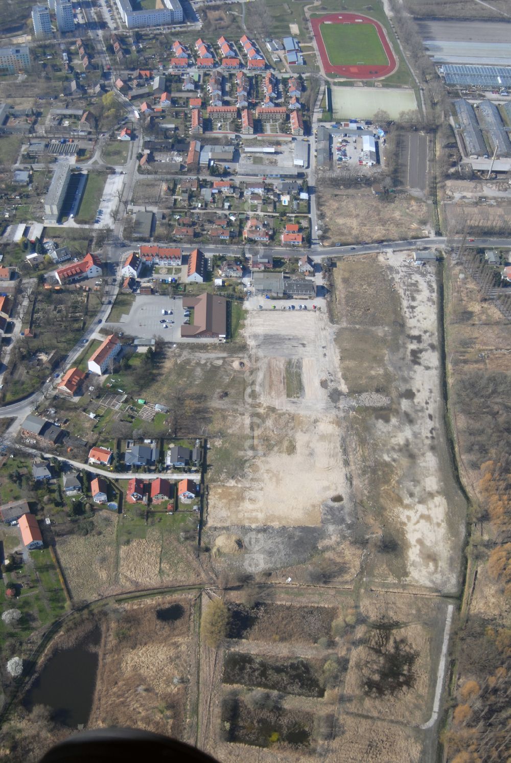 Aerial image Wartenberg - Blick auf die beräumte Fläche der einstigen DDR-Vorzeige LPG 1. Mai in Wartenberg. Die in Liquidation befindliche Landwirtschaftliche Produktionsgenossenschaft wurde 1953 durch den Zusammenschluss von 45 Gärtnern, Bauern und Landarbeitern gegründet.Ab den 60er Jahren wurden hier die industriemäßige Produktion von Champignons betrieben. Anschrift: LPG 1.Mai i.L., Lindenbergerstr. 18, 13059 Berlin; Tel.: 030 9293146