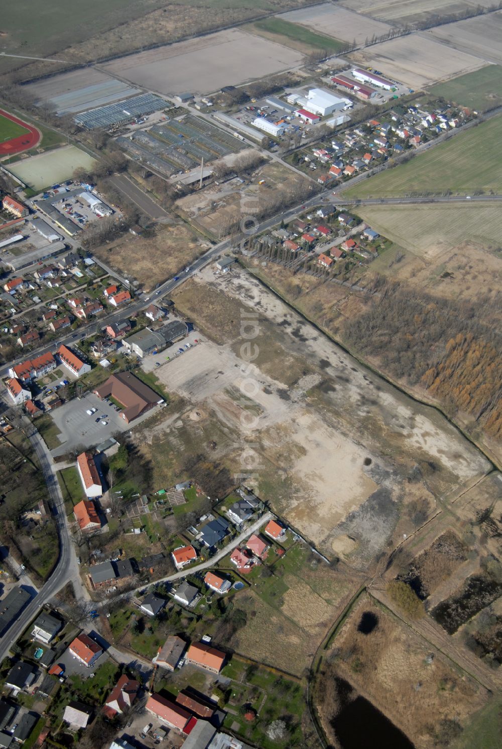 Aerial photograph Wartenberg - Blick auf die beräumte Fläche der einstigen DDR-Vorzeige LPG 1. Mai in Wartenberg. Die in Liquidation befindliche Landwirtschaftliche Produktionsgenossenschaft wurde 1953 durch den Zusammenschluss von 45 Gärtnern, Bauern und Landarbeitern gegründet.Ab den 60er Jahren wurden hier die industriemäßige Produktion von Champignons betrieben. Anschrift: LPG 1.Mai i.L., Lindenbergerstr. 18, 13059 Berlin; Tel.: 030 9293146