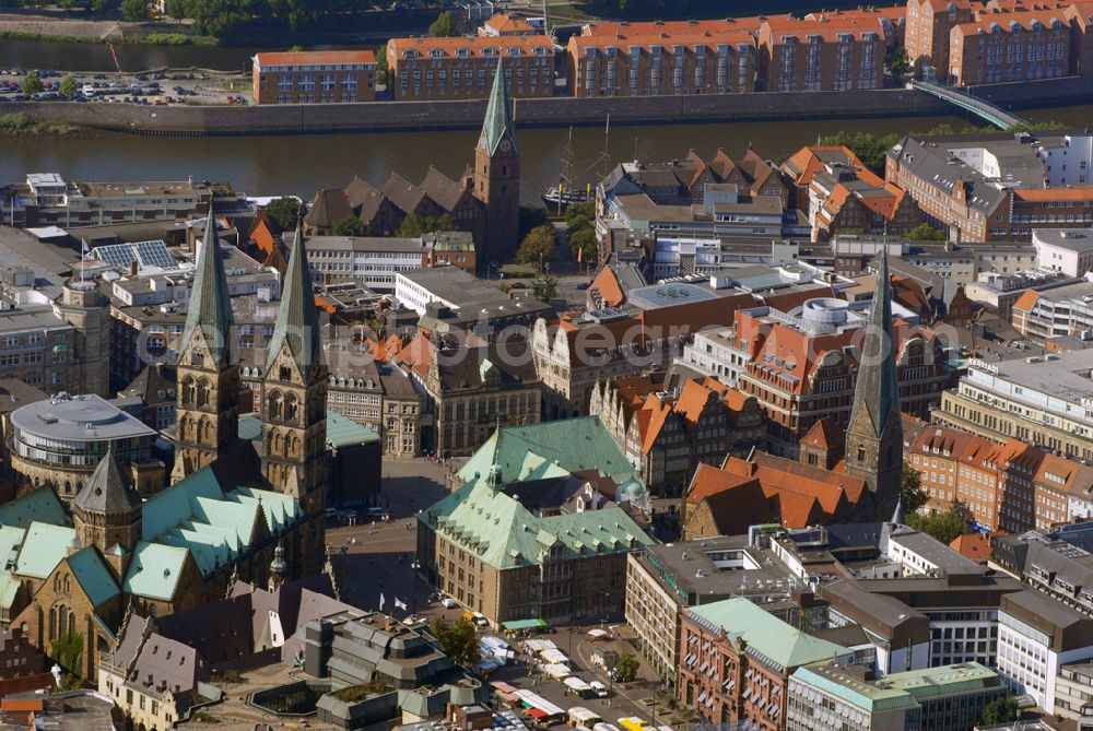 Aerial photograph Bremen - Blick auf die Bremer Altstadt mit dem Bremer Rathaus und dem Marktplatz.Das Bremer Rathaus liegt mitten in der Bremer Altstadt am Marktplatz. Gegenüber befindet sich der Schütting, direkt davor der Bremer Roland, rechts der Bremer Dom und das moderne Gebäude der Bremer Bürgerschaft, links die Kirche Unser Lieben Frauen. An der Westseite steht die Bronzeplastik der Bremer Stadtmusikanten von Gerhard Marcks. Adresse: Bremer Rathaus, Am Markt 21, 28195 Bremen Das Alte Rathaus wurde 1405-1409 als gotischer Saalgeschossbau erbaut. Der bremische Baumeister Lüder von Bentheim (ca. 1555-1612) renovierte von 1595-1612 das Rathaus und gestaltete die neue Fassade zum Markt hin. Die Fassade im Stil der Weserrenaissance zeigt Architekturelemente nach Entwürfen von Meistern der niederländischen Renaissance wie Hans Vredeman de Vries, Hendrick Goltzius und Jacob Floris. 1909-1913 erweiterte der Münchener Architekt Gabriel von Seidl das Rathaus durch einen rückwärtigen Anbau im Stil der Neorenaissance. Durch Verschalung der Aussenwände überstanden Rathaus und Roland die Bomben des 2. Weltkriegs, die mehr als 60 % von Bremen zerstörten, weitgehend unbeschädigt. Es wurde mehrfach, zuletzt 2003, restauriert.