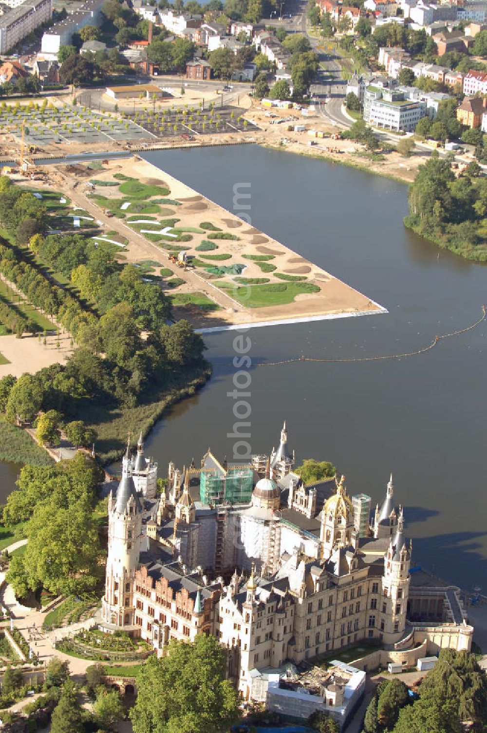 Aerial image Schwerin - Blick auf das BUGA 2009 - Gelände rund um den Schweriner See. Im Mittelpunkt der Bundesgartenschau, welche 2009 zum zweiten Mal in Mecklenburg-Vorpommern stattfindet, steht die geschichtliche Entwicklung der Gartenbaukunst. Die Ausstellungsareale sammeln sich kompakt um das Schweriner Schloss bzw. die Altstadt. Die insgesamt sieben Gärten, welche alle in Wassernähe liegen, werden durch eine Vielzahl von Umlandprojekten in ganz Mecklenburg-Vorpommern ergänzt. Die BUGA 2009 findet auf einer Gesamtfläche von 550.000 qm statt und kostet 72,2 Mio. Euro. Kontakt: Bundesgartenschau Schwerin 2009 GmbH, Eckdrift 43 - 45, 19061 Schwerin, Tel. +49 (0)385 2009 0, Fax +49 (0)385 2009 111, EMail info@buga-2009.de