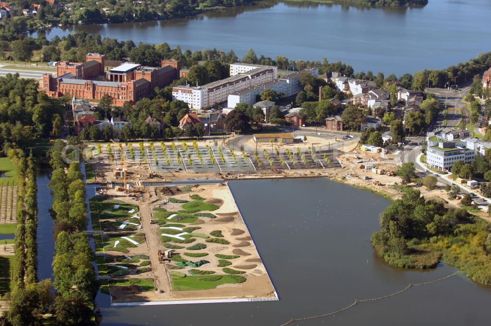 Aerial photograph Schwerin - Blick auf das BUGA 2009 - Gelände rund um den Schweriner See. Im Mittelpunkt der Bundesgartenschau, welche 2009 zum zweiten Mal in Mecklenburg-Vorpommern stattfindet, steht die geschichtliche Entwicklung der Gartenbaukunst. Die Ausstellungsareale sammeln sich kompakt um das Schweriner Schloss bzw. die Altstadt. Die insgesamt sieben Gärten, welche alle in Wassernähe liegen, werden durch eine Vielzahl von Umlandprojekten in ganz Mecklenburg-Vorpommern ergänzt. Die BUGA 2009 findet auf einer Gesamtfläche von 550.000 qm statt und kostet 72,2 Mio. Euro. Kontakt: Bundesgartenschau Schwerin 2009 GmbH, Eckdrift 43 - 45, 19061 Schwerin, Tel. +49 (0)385 2009 0, Fax +49 (0)385 2009 111, EMail info@buga-2009.de