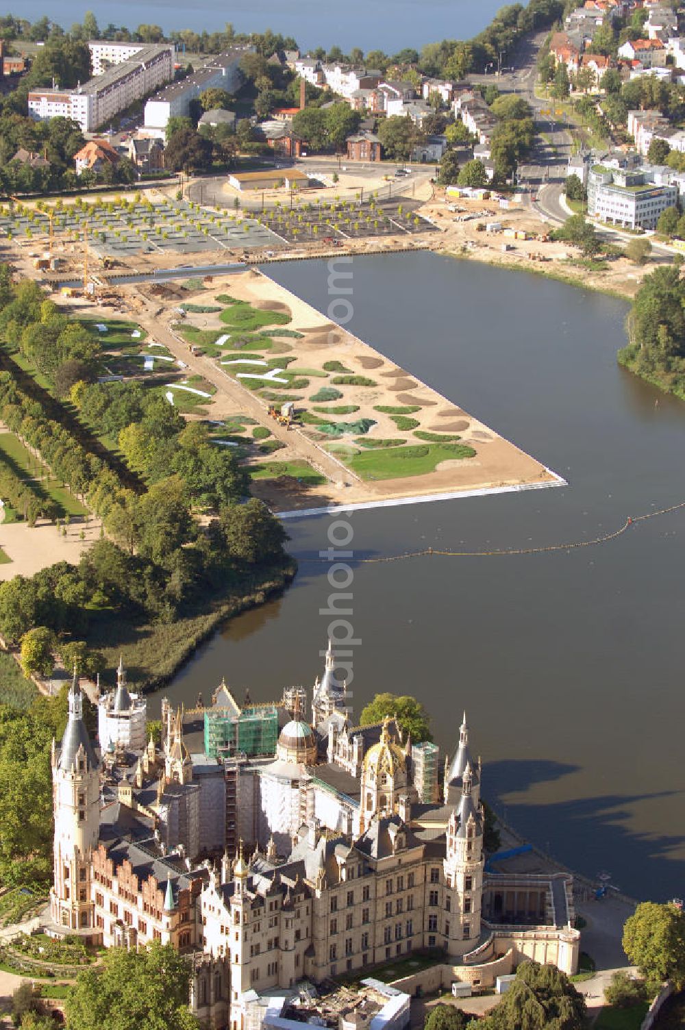 Schwerin from the bird's eye view: Blick auf das BUGA 2009 - Gelände rund um den Schweriner See. Im Mittelpunkt der Bundesgartenschau, welche 2009 zum zweiten Mal in Mecklenburg-Vorpommern stattfindet, steht die geschichtliche Entwicklung der Gartenbaukunst. Die Ausstellungsareale sammeln sich kompakt um das Schweriner Schloss bzw. die Altstadt. Die insgesamt sieben Gärten, welche alle in Wassernähe liegen, werden durch eine Vielzahl von Umlandprojekten in ganz Mecklenburg-Vorpommern ergänzt. Die BUGA 2009 findet auf einer Gesamtfläche von 550.000 qm statt und kostet 72,2 Mio. Euro. Kontakt: Bundesgartenschau Schwerin 2009 GmbH, Eckdrift 43 - 45, 19061 Schwerin, Tel. +49 (0)385 2009 0, Fax +49 (0)385 2009 111, EMail info@buga-2009.de