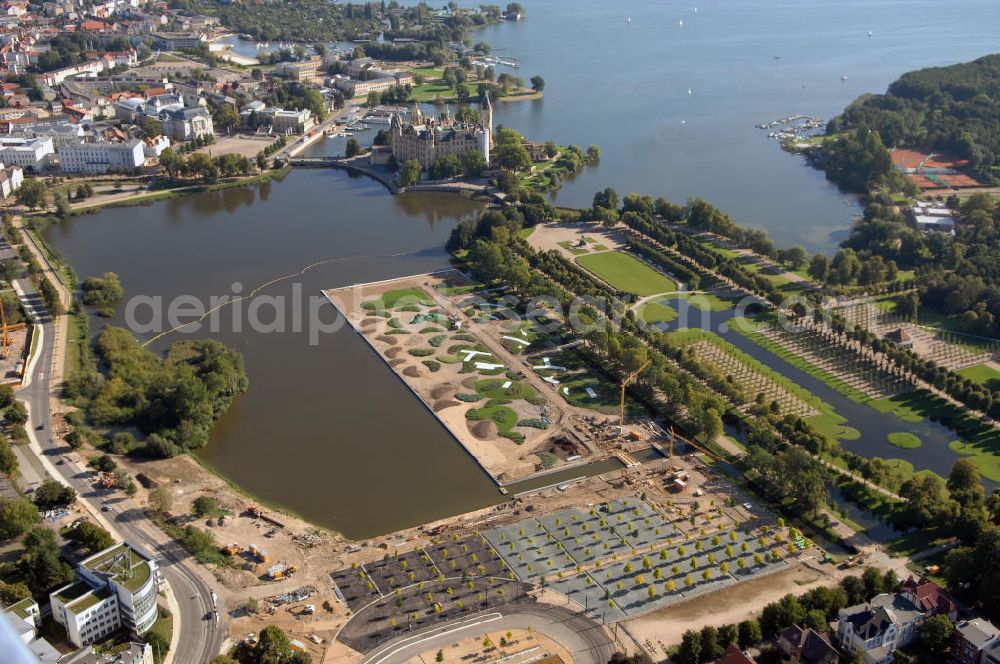 Schwerin from above - Blick auf das BUGA 2009 - Gelände rund um den Schweriner See. Im Mittelpunkt der Bundesgartenschau, welche 2009 zum zweiten Mal in Mecklenburg-Vorpommern stattfindet, steht die geschichtliche Entwicklung der Gartenbaukunst. Die Ausstellungsareale sammeln sich kompakt um das Schweriner Schloss bzw. die Altstadt. Die insgesamt sieben Gärten, welche alle in Wassernähe liegen, werden durch eine Vielzahl von Umlandprojekten in ganz Mecklenburg-Vorpommern ergänzt. Die BUGA 2009 findet auf einer Gesamtfläche von 550.000 qm statt und kostet 72,2 Mio. Euro. Kontakt: Bundesgartenschau Schwerin 2009 GmbH, Eckdrift 43 - 45, 19061 Schwerin, Tel. +49 (0)385 2009 0, Fax +49 (0)385 2009 111, EMail info@buga-2009.de