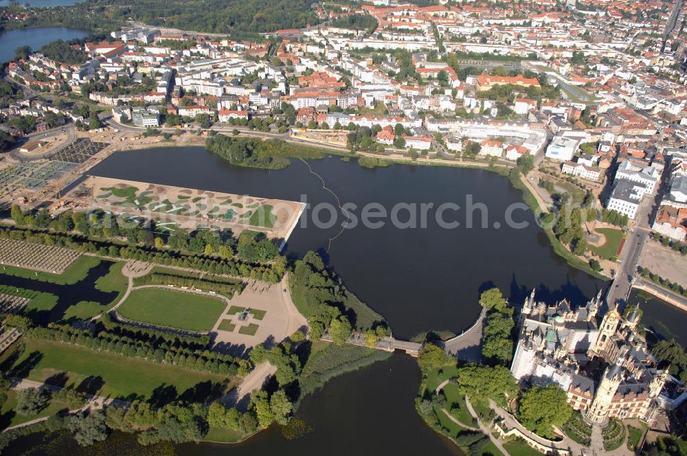 Aerial photograph Schwerin - Blick auf das BUGA 2009 - Gelände rund um den Schweriner See. Im Mittelpunkt der Bundesgartenschau, welche 2009 zum zweiten Mal in Mecklenburg-Vorpommern stattfindet, steht die geschichtliche Entwicklung der Gartenbaukunst. Die Ausstellungsareale sammeln sich kompakt um das Schweriner Schloss bzw. die Altstadt. Die insgesamt sieben Gärten, welche alle in Wassernähe liegen, werden durch eine Vielzahl von Umlandprojekten in ganz Mecklenburg-Vorpommern ergänzt. Die BUGA 2009 findet auf einer Gesamtfläche von 550.000 qm statt und kostet 72,2 Mio. Euro. Kontakt: Bundesgartenschau Schwerin 2009 GmbH, Eckdrift 43 - 45, 19061 Schwerin, Tel. +49 (0)385 2009 0, Fax +49 (0)385 2009 111, EMail info@buga-2009.de