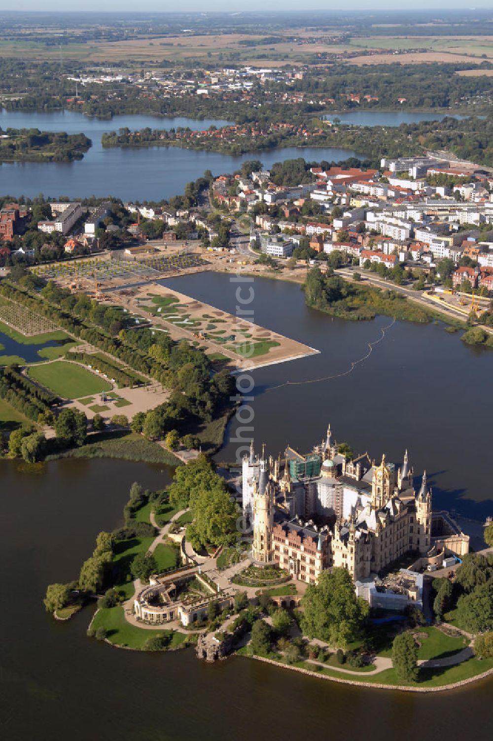 Schwerin from the bird's eye view: Blick auf das BUGA 2009 - Gelände rund um den Schweriner See. Im Mittelpunkt der Bundesgartenschau, welche 2009 zum zweiten Mal in Mecklenburg-Vorpommern stattfindet, steht die geschichtliche Entwicklung der Gartenbaukunst. Die Ausstellungsareale sammeln sich kompakt um das Schweriner Schloss bzw. die Altstadt. Die insgesamt sieben Gärten, welche alle in Wassernähe liegen, werden durch eine Vielzahl von Umlandprojekten in ganz Mecklenburg-Vorpommern ergänzt. Die BUGA 2009 findet auf einer Gesamtfläche von 550.000 qm statt und kostet 72,2 Mio. Euro. Kontakt: Bundesgartenschau Schwerin 2009 GmbH, Eckdrift 43 - 45, 19061 Schwerin, Tel. +49 (0)385 2009 0, Fax +49 (0)385 2009 111, EMail info@buga-2009.de