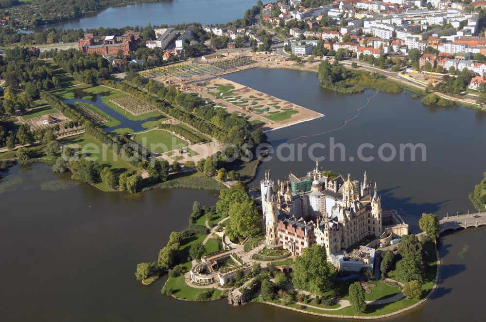 Aerial image Schwerin - Blick auf das BUGA 2009 - Gelände rund um den Schweriner See. Im Mittelpunkt der Bundesgartenschau, welche 2009 zum zweiten Mal in Mecklenburg-Vorpommern stattfindet, steht die geschichtliche Entwicklung der Gartenbaukunst. Die Ausstellungsareale sammeln sich kompakt um das Schweriner Schloss bzw. die Altstadt. Die insgesamt sieben Gärten, welche alle in Wassernähe liegen, werden durch eine Vielzahl von Umlandprojekten in ganz Mecklenburg-Vorpommern ergänzt. Die BUGA 2009 findet auf einer Gesamtfläche von 550.000 qm statt und kostet 72,2 Mio. Euro. Kontakt: Bundesgartenschau Schwerin 2009 GmbH, Eckdrift 43 - 45, 19061 Schwerin, Tel. +49 (0)385 2009 0, Fax +49 (0)385 2009 111, EMail info@buga-2009.de