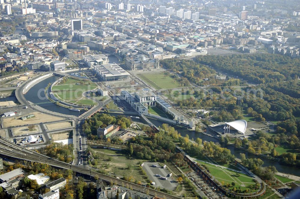 Aerial photograph Berlin - Das Bundeskanzleramt (Abkürzung BK) ist eine Oberste Bundesbehörde. Das gleichermaßen spektakuläre wie umstrittene monumentale Gebäudeensemble des neuen Bundeskanzleramtes wurde von den Berliner Architekten Axel Schultes und Charlotte Frank in der Amtszeit von Kanzler Helmut Kohl (1982–1998) entworfen. Nach dem ersten Spatenstich am 4. Februar 1997 und knapp vierjähriger Bauzeit konnte das Gebäude am 2. Mai 2001 vom damaligen Bundeskanzler Gerhard Schröder bezogen werden, wodurch der Regierungsumzug nach Berlin abgeschlossen wurde. Das bebaute Grundstück ist mit Hubschrauberlandeplatz und Kanzlerpark 73.000 m² groß. Mit einer Gesamtfläche von 12.000 m² und einer Höhe von 36 m übertrifft das Gebäude die Berliner Traufhöhe von 22 m und ist eines der größten Regierungshauptquartiere der Welt (achtmal so groß wie das Weiße Haus).