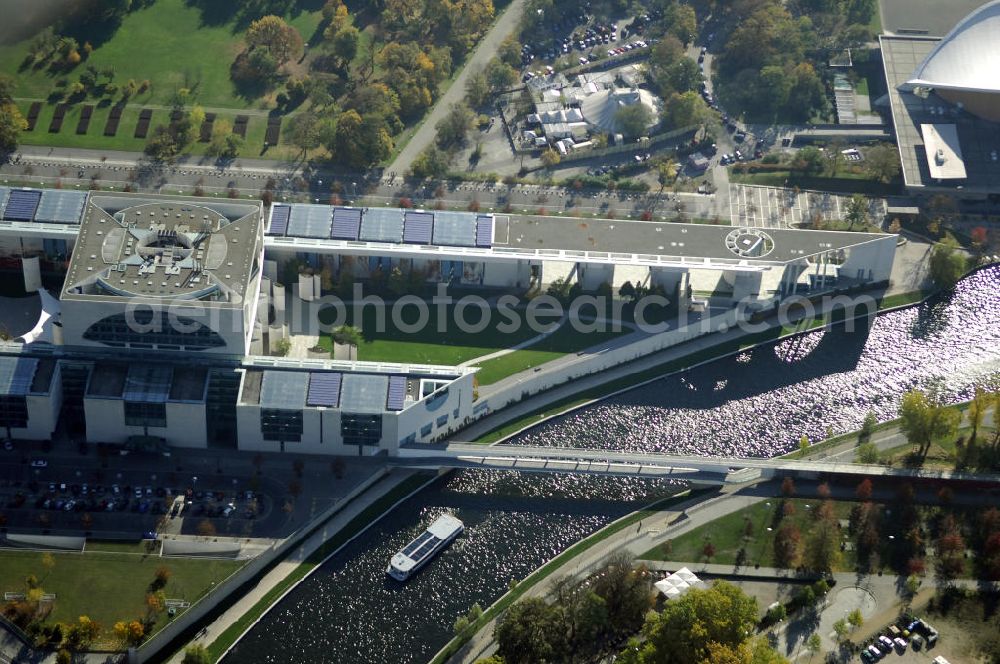 Aerial image Berlin - Das Bundeskanzleramt (Abkürzung BK) ist eine Oberste Bundesbehörde. Das gleichermaßen spektakuläre wie umstrittene monumentale Gebäudeensemble des neuen Bundeskanzleramtes wurde von den Berliner Architekten Axel Schultes und Charlotte Frank in der Amtszeit von Kanzler Helmut Kohl (1982–1998) entworfen. Nach dem ersten Spatenstich am 4. Februar 1997 und knapp vierjähriger Bauzeit konnte das Gebäude am 2. Mai 2001 vom damaligen Bundeskanzler Gerhard Schröder bezogen werden, wodurch der Regierungsumzug nach Berlin abgeschlossen wurde. Das bebaute Grundstück ist mit Hubschrauberlandeplatz und Kanzlerpark 73.000 m² groß. Mit einer Gesamtfläche von 12.000 m² und einer Höhe von 36 m übertrifft das Gebäude die Berliner Traufhöhe von 22 m und ist eines der größten Regierungshauptquartiere der Welt (achtmal so groß wie das Weiße Haus).