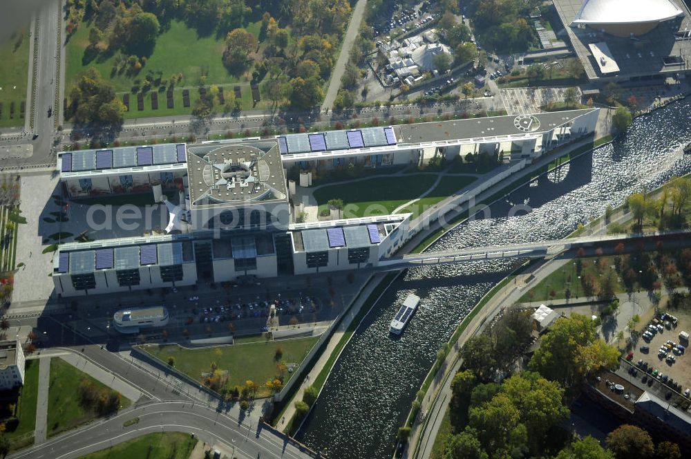 Aerial photograph Berlin - Das Bundeskanzleramt (Abkürzung BK) ist eine Oberste Bundesbehörde. Das gleichermaßen spektakuläre wie umstrittene monumentale Gebäudeensemble des neuen Bundeskanzleramtes wurde von den Berliner Architekten Axel Schultes und Charlotte Frank in der Amtszeit von Kanzler Helmut Kohl (1982–1998) entworfen. Nach dem ersten Spatenstich am 4. Februar 1997 und knapp vierjähriger Bauzeit konnte das Gebäude am 2. Mai 2001 vom damaligen Bundeskanzler Gerhard Schröder bezogen werden, wodurch der Regierungsumzug nach Berlin abgeschlossen wurde. Das bebaute Grundstück ist mit Hubschrauberlandeplatz und Kanzlerpark 73.000 m² groß. Mit einer Gesamtfläche von 12.000 m² und einer Höhe von 36 m übertrifft das Gebäude die Berliner Traufhöhe von 22 m und ist eines der größten Regierungshauptquartiere der Welt (achtmal so groß wie das Weiße Haus).