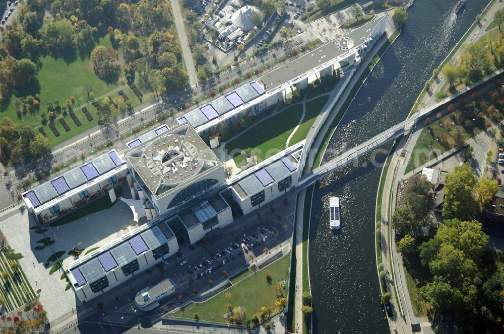 Berlin from above - Das Bundeskanzleramt (Abkürzung BK) ist eine Oberste Bundesbehörde. Das gleichermaßen spektakuläre wie umstrittene monumentale Gebäudeensemble des neuen Bundeskanzleramtes wurde von den Berliner Architekten Axel Schultes und Charlotte Frank in der Amtszeit von Kanzler Helmut Kohl (1982–1998) entworfen. Nach dem ersten Spatenstich am 4. Februar 1997 und knapp vierjähriger Bauzeit konnte das Gebäude am 2. Mai 2001 vom damaligen Bundeskanzler Gerhard Schröder bezogen werden, wodurch der Regierungsumzug nach Berlin abgeschlossen wurde. Das bebaute Grundstück ist mit Hubschrauberlandeplatz und Kanzlerpark 73.000 m² groß. Mit einer Gesamtfläche von 12.000 m² und einer Höhe von 36 m übertrifft das Gebäude die Berliner Traufhöhe von 22 m und ist eines der größten Regierungshauptquartiere der Welt (achtmal so groß wie das Weiße Haus).