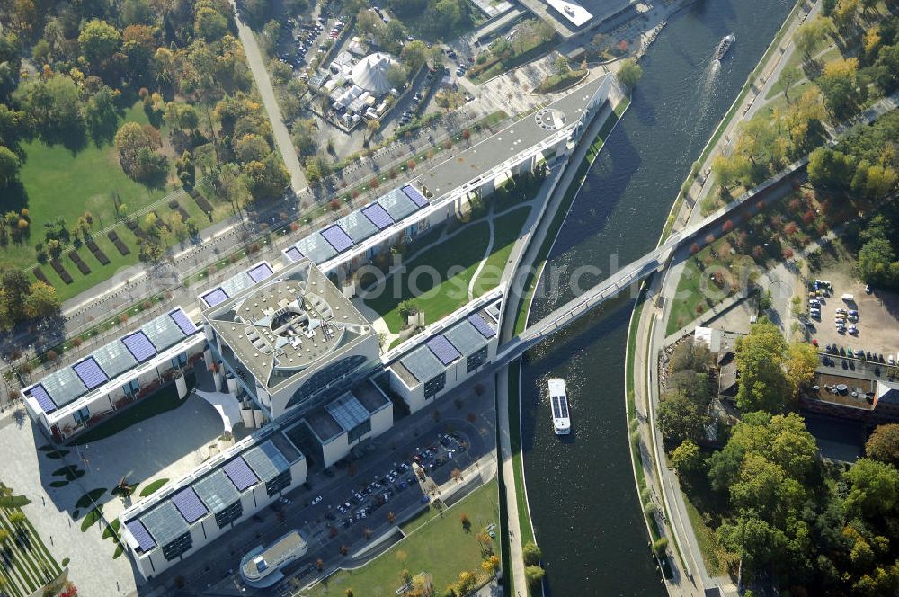 Berlin from the bird's eye view: Das Bundeskanzleramt (Abkürzung BK) ist eine Oberste Bundesbehörde. Das gleichermaßen spektakuläre wie umstrittene monumentale Gebäudeensemble des neuen Bundeskanzleramtes wurde von den Berliner Architekten Axel Schultes und Charlotte Frank in der Amtszeit von Kanzler Helmut Kohl (1982–1998) entworfen. Nach dem ersten Spatenstich am 4. Februar 1997 und knapp vierjähriger Bauzeit konnte das Gebäude am 2. Mai 2001 vom damaligen Bundeskanzler Gerhard Schröder bezogen werden, wodurch der Regierungsumzug nach Berlin abgeschlossen wurde. Das bebaute Grundstück ist mit Hubschrauberlandeplatz und Kanzlerpark 73.000 m² groß. Mit einer Gesamtfläche von 12.000 m² und einer Höhe von 36 m übertrifft das Gebäude die Berliner Traufhöhe von 22 m und ist eines der größten Regierungshauptquartiere der Welt (achtmal so groß wie das Weiße Haus).