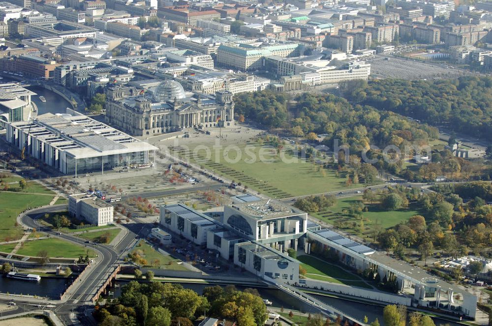 Aerial photograph Berlin - Das Bundeskanzleramt (Abkürzung BK) ist eine Oberste Bundesbehörde. Das gleichermaßen spektakuläre wie umstrittene monumentale Gebäudeensemble des neuen Bundeskanzleramtes wurde von den Berliner Architekten Axel Schultes und Charlotte Frank in der Amtszeit von Kanzler Helmut Kohl (1982–1998) entworfen. Nach dem ersten Spatenstich am 4. Februar 1997 und knapp vierjähriger Bauzeit konnte das Gebäude am 2. Mai 2001 vom damaligen Bundeskanzler Gerhard Schröder bezogen werden, wodurch der Regierungsumzug nach Berlin abgeschlossen wurde. Das bebaute Grundstück ist mit Hubschrauberlandeplatz und Kanzlerpark 73.000 m² groß. Mit einer Gesamtfläche von 12.000 m² und einer Höhe von 36 m übertrifft das Gebäude die Berliner Traufhöhe von 22 m und ist eines der größten Regierungshauptquartiere der Welt (achtmal so groß wie das Weiße Haus).