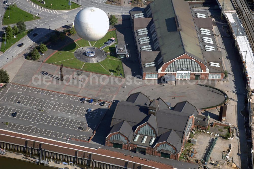 Aerial photograph Hamburg - Blick auf die Deichtorhallen und den Highflyer Fesselballon in Hamburg. Die Deichtorhallen sind Europas größte Kunstausstellungshallen und gliedern sich in das Haus der Photographie und eine zweite Ausstellungshalle für aktuelle Kunst. Hier finden nicht nur Ausstellungen schon großer und namhafter Künstler statt, auch junge noch unbekannte Künstler bekommen immer wieder die Möglichkeit ihre Werke in einem recht großen Rahmen auszustellen. Neben den Ausstellungsräumen gibt es auch einen Design- und Buchshop der Photographie, sowie ein Restaurant. Zwischen den beiden Gebäuden der Deichtorhallen befindet sich eine weitere Touristenattraktion, der Highflyer Fesselballon. Er ist fest installiert und an einem 180 Meter langen Drahtseil befestigt um immer wieder an der gleichen Stellen landen zu können. Mit ihm können 30 Personen in die Luft steigen und die Aussicht auf und über Hamburg genießen. Kontakt: Deichtorhallen Hamburg GmbH, Deichtorstraße 1-2 20095 Hamburg, Tel. +49(0)40 3210 30, Fax +49(0)40 3210 3230, Email: mail@deichtorhallen.de