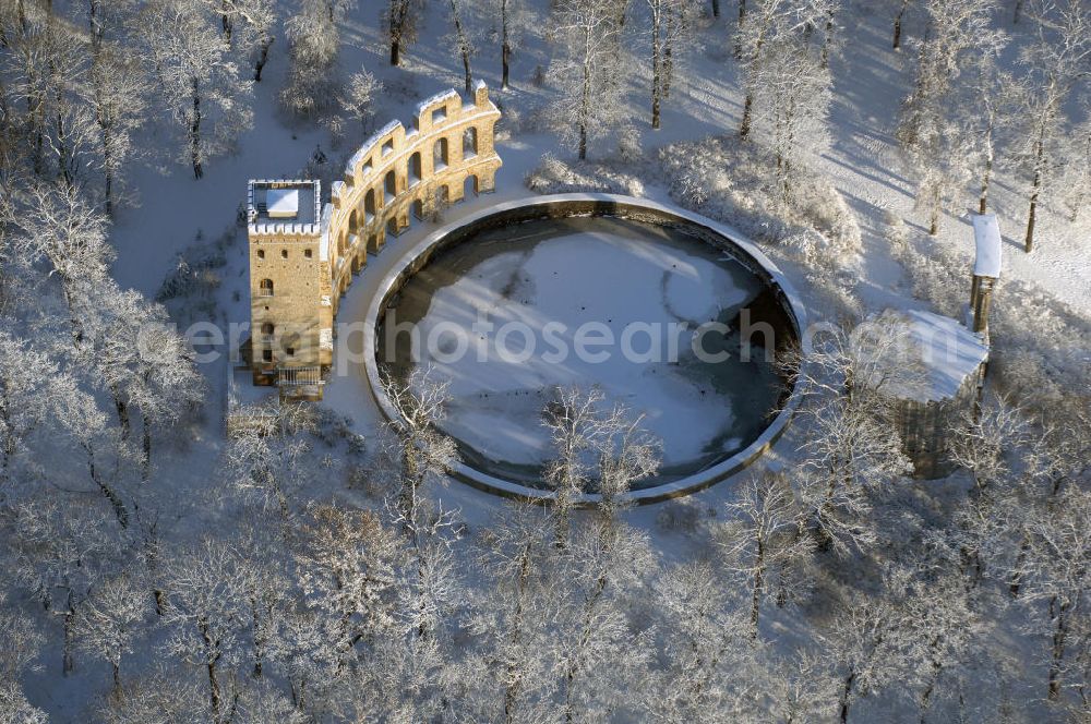 Aerial image POTSDAM - Blick auf den winterlich verschneiten Ruinenberg, einer Anhöhe zwischen Potsdam-Bornstedt im Westen und der Potsdamer Jägervorstadt im Osten. Zur Bewässerung der Fontänen im südlich angrenzenden Park Sanssouci ließ Friedrich der Große 1748 auf der Kuppe ein Wasserreservoir bauen und mit künstlichen Ruinen als antikisierende Gestaltungselemente ausschmücken. Im Zuge der Landschaftsverschönerung um Potsdam beauftragte Friedrich Wilhelm IV. den Gartenarchitekten Peter Joseph Lenné 1841 mit der gärtnerischen Gestaltung des Ruinenberggeländes.