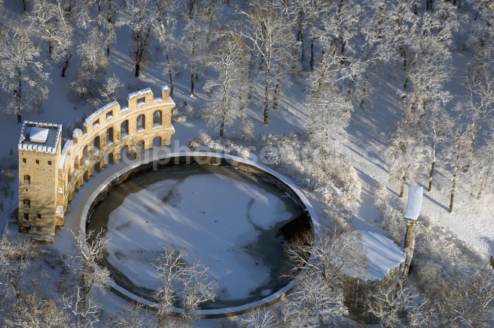 Aerial photograph POTSDAM - Blick auf den winterlich verschneiten Ruinenberg, einer Anhöhe zwischen Potsdam-Bornstedt im Westen und der Potsdamer Jägervorstadt im Osten. Zur Bewässerung der Fontänen im südlich angrenzenden Park Sanssouci ließ Friedrich der Große 1748 auf der Kuppe ein Wasserreservoir bauen und mit künstlichen Ruinen als antikisierende Gestaltungselemente ausschmücken. Im Zuge der Landschaftsverschönerung um Potsdam beauftragte Friedrich Wilhelm IV. den Gartenarchitekten Peter Joseph Lenné 1841 mit der gärtnerischen Gestaltung des Ruinenberggeländes.