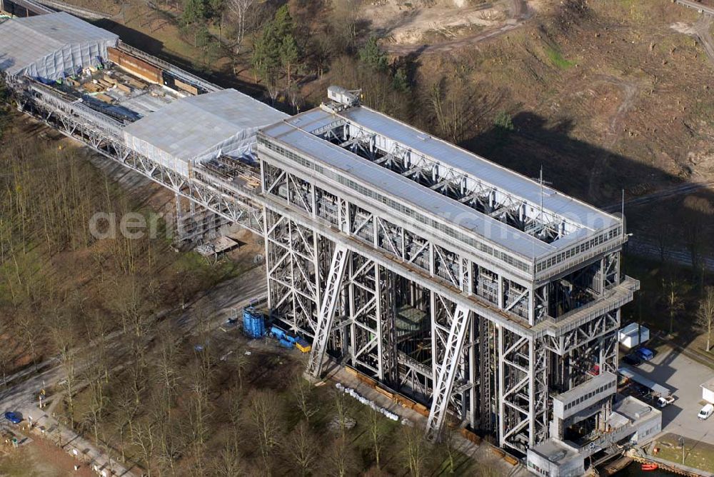 Niederfinow from the bird's eye view: Blick auf derzeitige Wartungsarbeiten am Schiffshebewerk Niederfinow mit trockengelegter Kanalbrücke. Das Schiffshebewerk an der Oder-Havel-Wasserstraße ist wegenWartungsarbeiten gesperrt worden. Dieses Jahr dauert die Sperrung bis zum 31. März und damit zwölf statt sechs Wochen, da der Korrosionsschutz an der Kanalbrücke erneuert werden muss. Die Arbeiten finden in 40 Metern Höhe statt und kosten 3,1 Millionen Euro. Der Schiffsfahrstuhl gilt als Engpass auf dem Wasserweg zwischen Berlin und dem Ostseehafen Stettin (Szczecin). Darum ist ein Neubau in Planung, der in voraussichtlich fünf Jahren fertig gestellt sein wird. Das alte Schiffshebewerk hat noch eine so genannte nominale Restnutzungsdauer bis zum Jahr 2025 und bleibt nach dem Neubau des Schiffshebewerkes Niederfinow Nord betriebsbereit erhalten. Das Schiffshebewerk zieht jährlich zwischen 200 000 und 300 000 Besucher an.