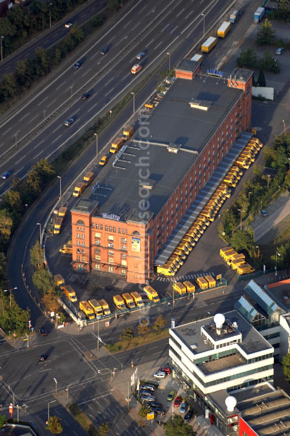 Aerial photograph Berlin - Blick auf eine Filiale der Post-Logistiktochter DHL in Berlin-Tempelhof an dem links verlaufenden Tempelhofer Damm. Die untere Straße ist die Schöneberger Straße, unter der das sich ebenfalls in dem Gebäude befindliche Fitnessstudio der McFit GmbH seine Anschrift hat. Kontakt: