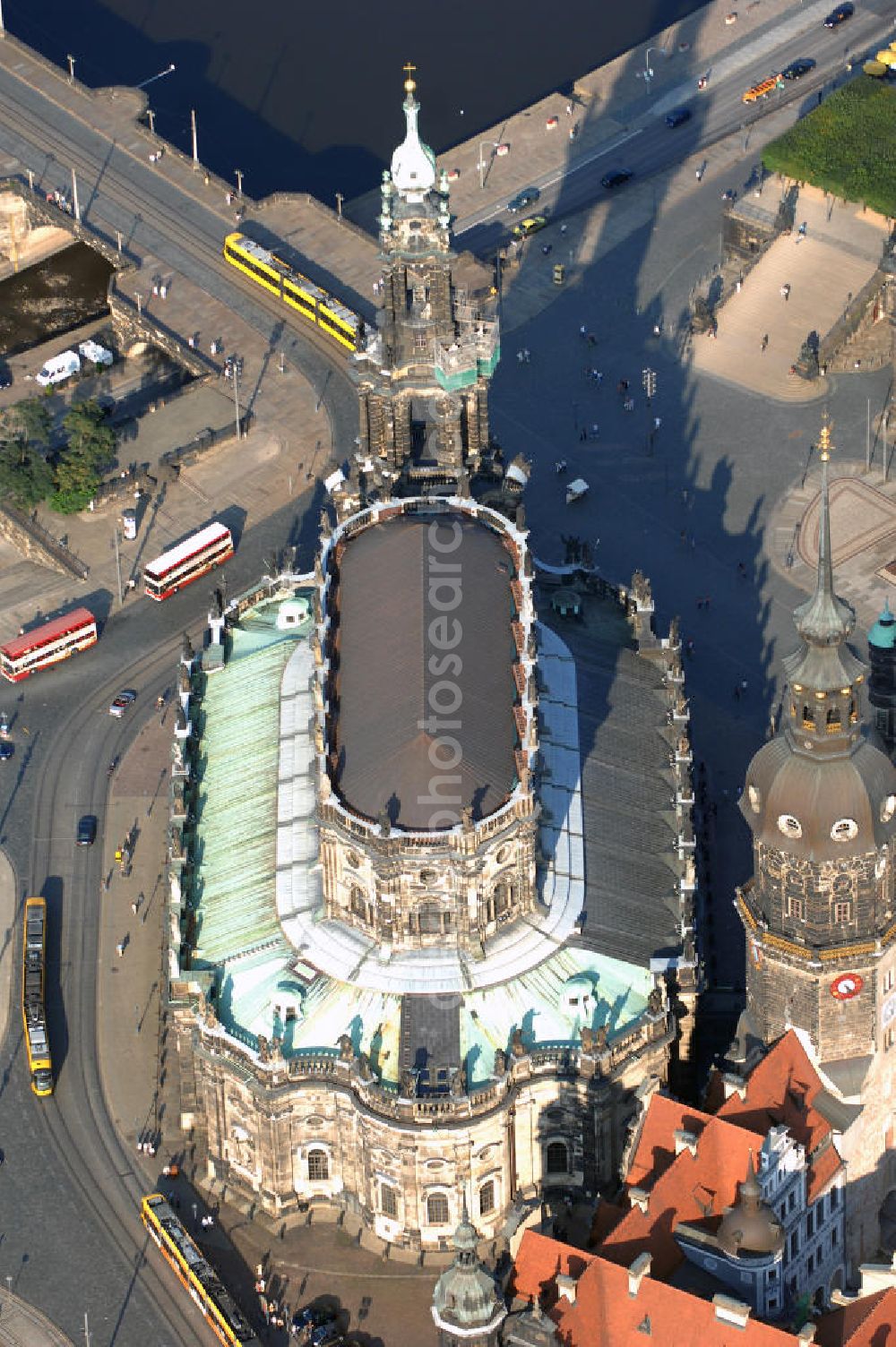 Dresden from the bird's eye view: Blick auf die ehemalige Hofkirche in Dresden gegenüber der bekannten Semperoper am Theaterplatz an der Elbe. Sie ist seit 1980 die Kathedrale des Bistums Dresden-Meißen weshalb sie heute den Namen Kathedrale Ss. Trinitatis trägt. Die Hofkirche gilt als einer der größten Kirchenbauten Sachsens und wurde von 1739 bis 1755 im Barockstil gebaut. Während des zweiten Weltkrieges wurde die Kirche bei mehreren Bombenangriffen zum Teil stark beschädigt, sodass der Wiederaufbau bis 1965 andauerte. Kontakt: Bischöfliches Ordinariat, Käthe-Kollwitz-Ufer 84 01309 Dresden, Tel. +49(0)351 3364 600, Email: kanzlei@ordinariat-dresden.de