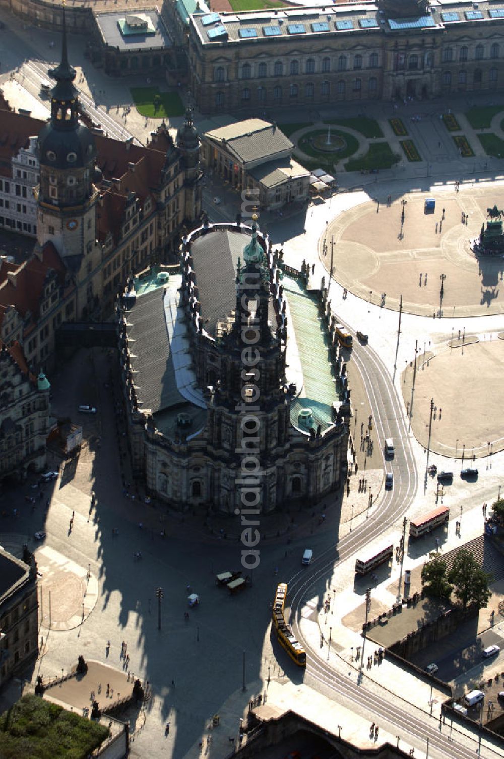 Aerial photograph Dresden - Blick auf die ehemalige Hofkirche in Dresden gegenüber der bekannten Semperoper am Theaterplatz an der Elbe. Sie ist seit 1980 die Kathedrale des Bistums Dresden-Meißen weshalb sie heute den Namen Kathedrale Ss. Trinitatis trägt. Die Hofkirche gilt als einer der größten Kirchenbauten Sachsens und wurde von 1739 bis 1755 im Barockstil gebaut. Während des zweiten Weltkrieges wurde die Kirche bei mehreren Bombenangriffen zum Teil stark beschädigt, sodass der Wiederaufbau bis 1965 andauerte. Kontakt: Bischöfliches Ordinariat, Käthe-Kollwitz-Ufer 84 01309 Dresden, Tel. +49(0)351 3364 600, Email: kanzlei@ordinariat-dresden.de