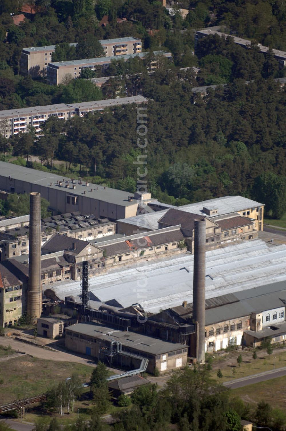 Premnitz from above - Blick auf die ehemalige Märkische Viskose GmbH. Sie begann ihre Produktion 1928 als TRAVIS-Kunstseide, sie hieß später SUPREMA und SERONA. 1949 wird er in den VEB Kunstseidenwerk Friedrich Engels umgewandelt. 1950 wird eine neue Anlage für Zellulose-Kunstseide nach dem Viskoseverfahren gebaut und in Betrieb genommen. Nach 1990 läuft der Betrieb unter verschiedenen Investoren weiter. Die Märkische Viskose GmbH ist Tochter der Märkischen Faser AG. 1996 übernimmt die spanische LA SEDA die Produktion und beendet diese 2000 wieder. Die Anlage wird 2001 als Prefil weitergeführt. Die Insolvenz und die Stilllegung im Juli 2002 kann jedoch nicht verhindert werden.