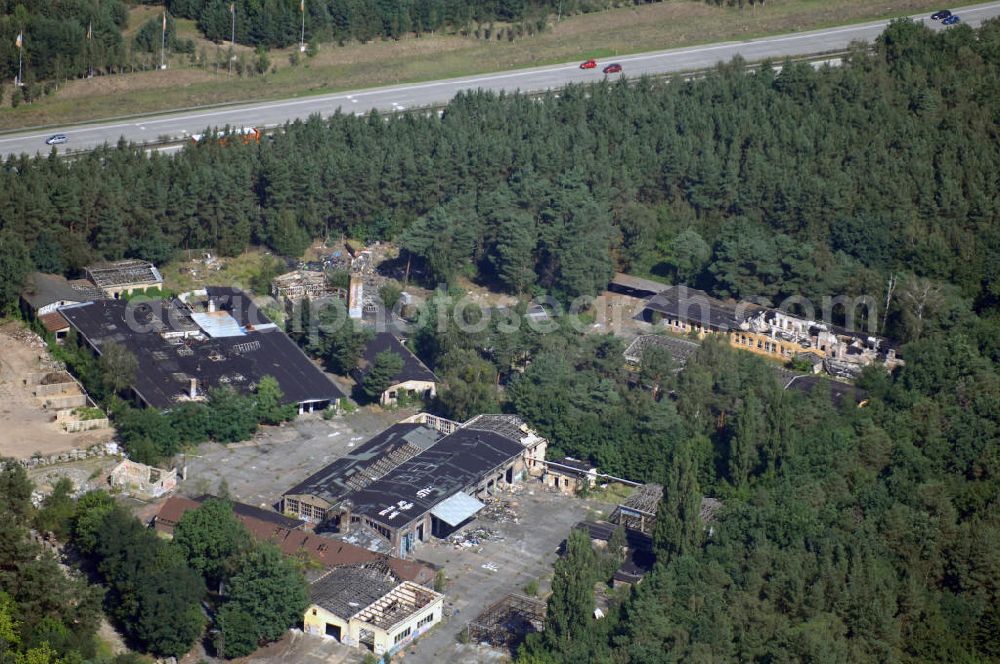 Aerial photograph Kleinmachnow - Blick auf ehemaliges Werks- und KZ-Gelände in Kleinmachnow. Das gesamte gezeigte Gelände befindet sich heute in einem desolaten und schwer sanierungsbedürftigen Zustand und wurde über die Planungs- und Entwicklungs- GmbH Kleinmachnow (P&E) unter der Bezeichnung Baufeld Nord für Investoren ausgewiesen. Vormals wurde hier bis 1945 eine Schattenfabrik betrieben. Die Dreilinden Maschinenbau GmbH, eine 100prozentige Tochtergesellschaft der Bosch AG, beschäftigte hier Zwangsarbeiter für die Rüstungsproduktion. Danach siedelte sich ein Instandsetzungswerk für LKW und Busse an. Mit der Wende gründete sich hier die Fath GmbH und ein Nebengeschäft des Subaru-Automobilkonzerns. Seit 2002 liegt das 33.500 qm große Gelände brach.