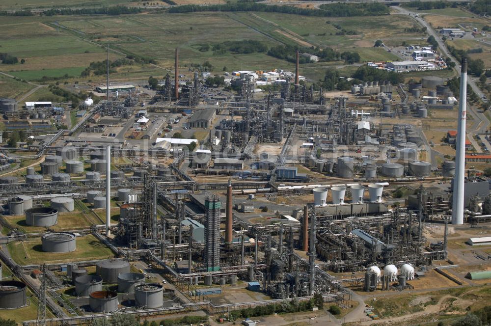 Hemmingstedt from above - Blick auf die Erdölraffinerie in Hemmingstedt. Sie ist einer der größten Arbeitgeber im Kreis und Grund dafür, dass auf Hemmingstedt als eine der wenigen Dithmarscher Gemeinden im Zweiten Weltkrieg Bombenangriffe geflogen wurden, mit entsprechenden Auswirkungen auf das Stadtbild. In der Raffinerie, die ehemals der DEA und seit der Fusion zu Shell gehört, werden im Jahr etwa vier Millionen Tonnen Rohöl verarbeitet. Dabei entstehen unter an derem Dieselkraftstoff, leichtes Heizöl, Flugturbinenkraftstoff und Grundstoffe für die chemische Industrie (Ethylen, Benzol, Ethylbenzol). Kam das Öl ursprünglich aus dem Ölfeld zwischen Hemmingstedt und Heide, so kam später über den Hafen Brunsbüttel importiertes Öl hinzu. 1991 versiegte das Feld bei Hemmingstedt, mittlerweile kommt aber etwa ein Drittel des Rohstoffs aus dem im nahen Watt gelegenen Ölfeld Mittelplate. Kontakt: Meldorfer Str. 43, 25770 Hemmingstedt, Tel. +49 (0)481 6930, Fax +49 (0)481 6932382